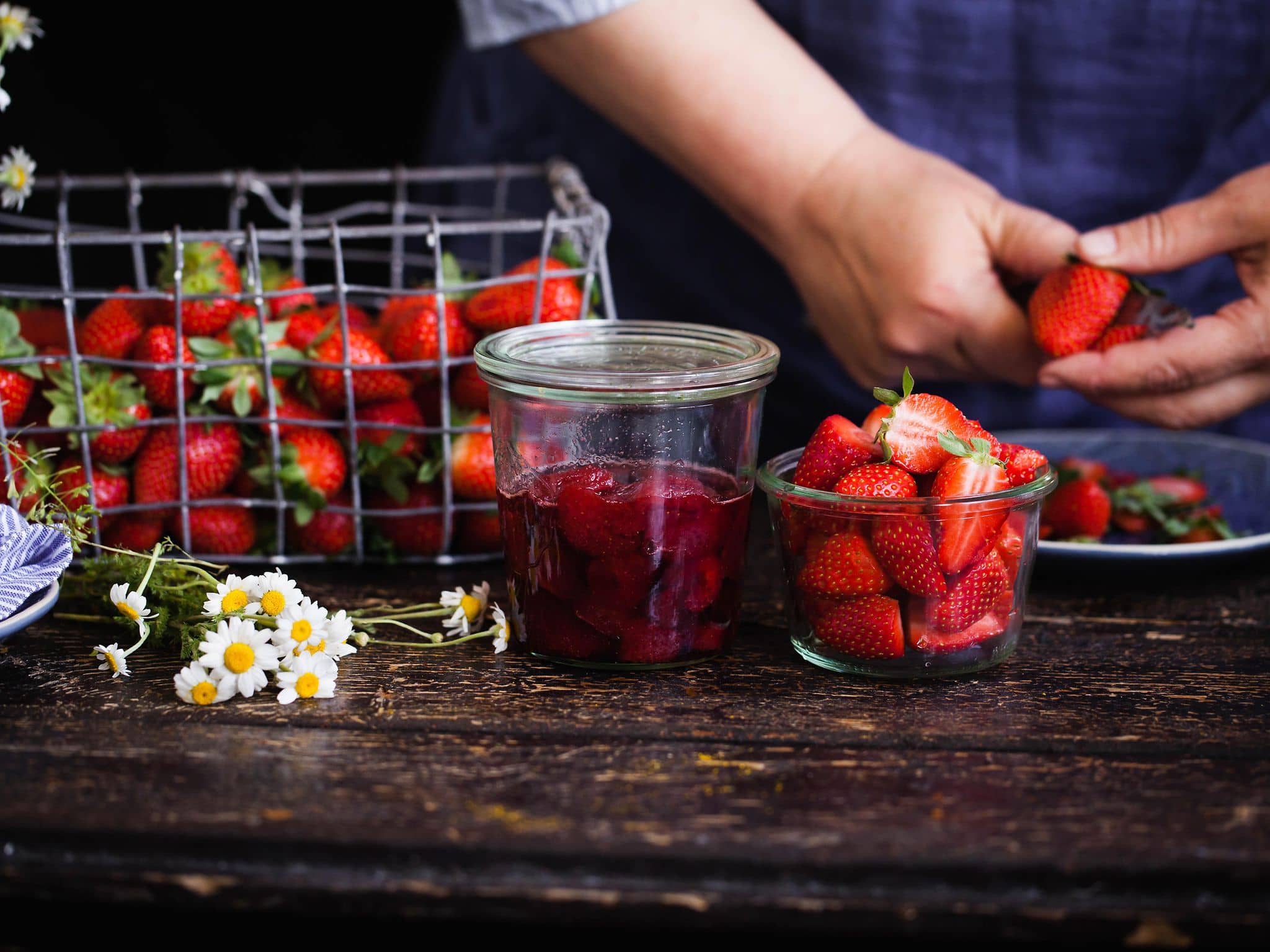 Zur Zubereitung von Marmelade werden Erdbeeren geschnitten
