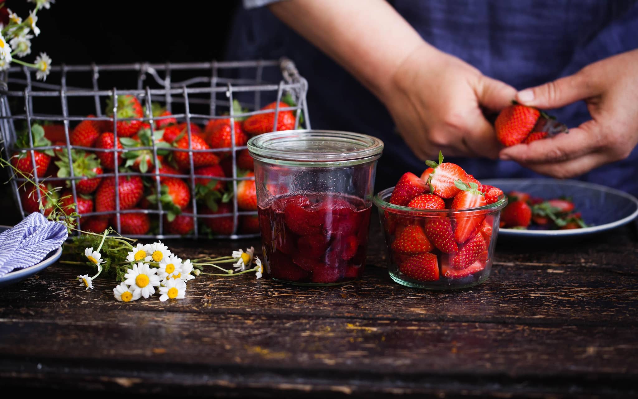 Zur Zubereitung von Marmelade werden Erdbeeren geschnitten