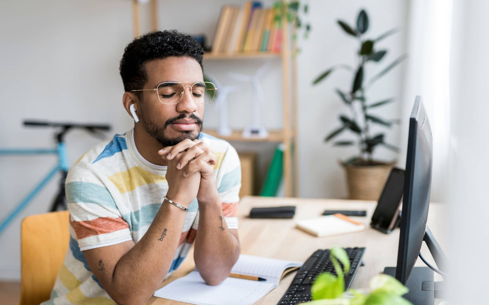 Achtsamkeit im Alltag: Ein Mann sitzt an einem Schreibtisch und entspannt