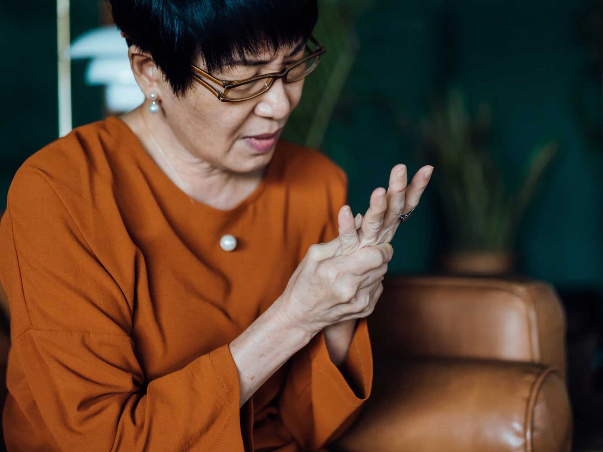 Ältere Frau reibt sich die linke Hand