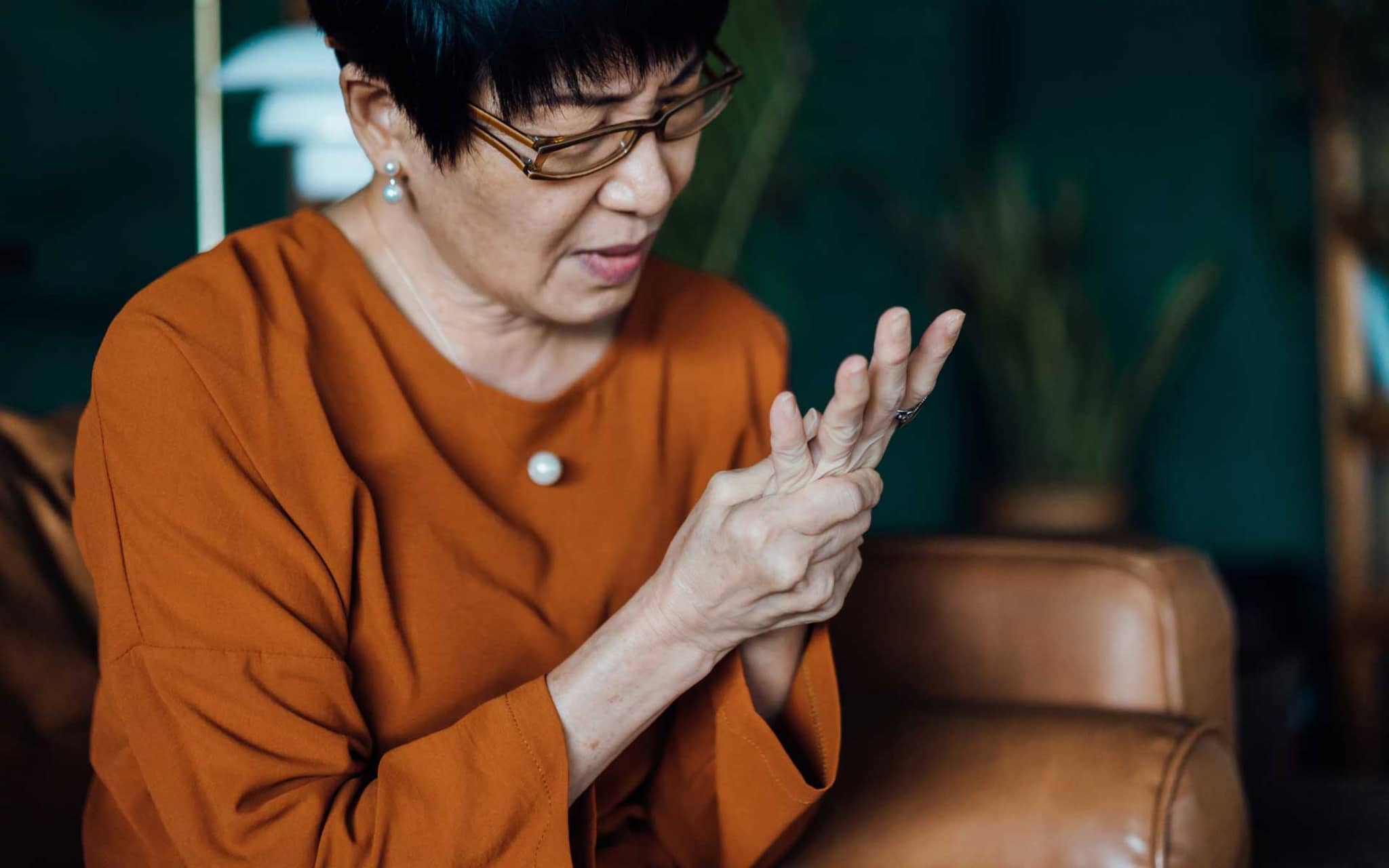 Ältere Frau reibt sich die linke Hand