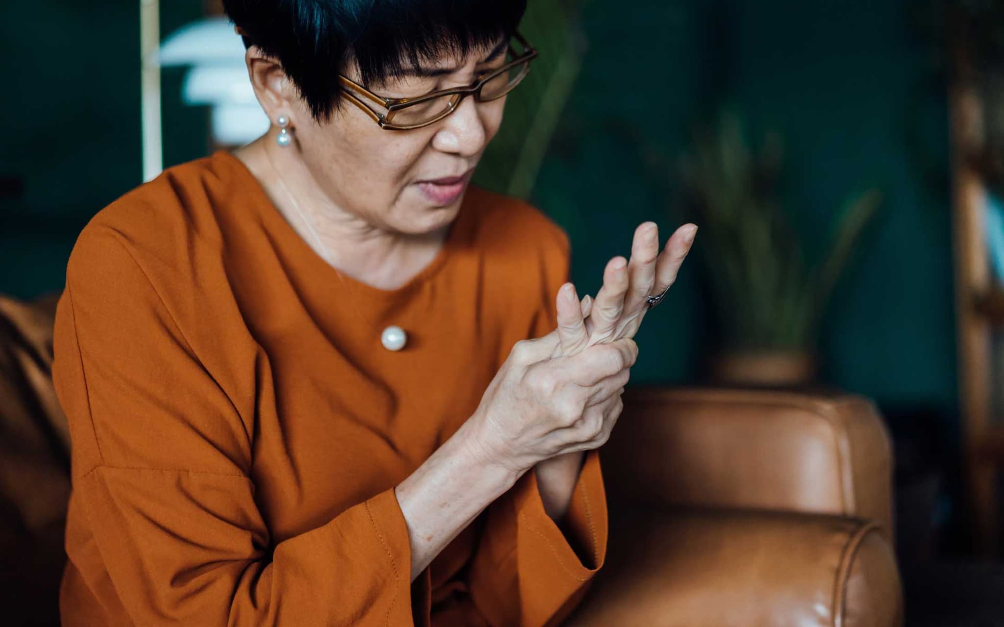 Ältere Frau reibt sich die linke Hand