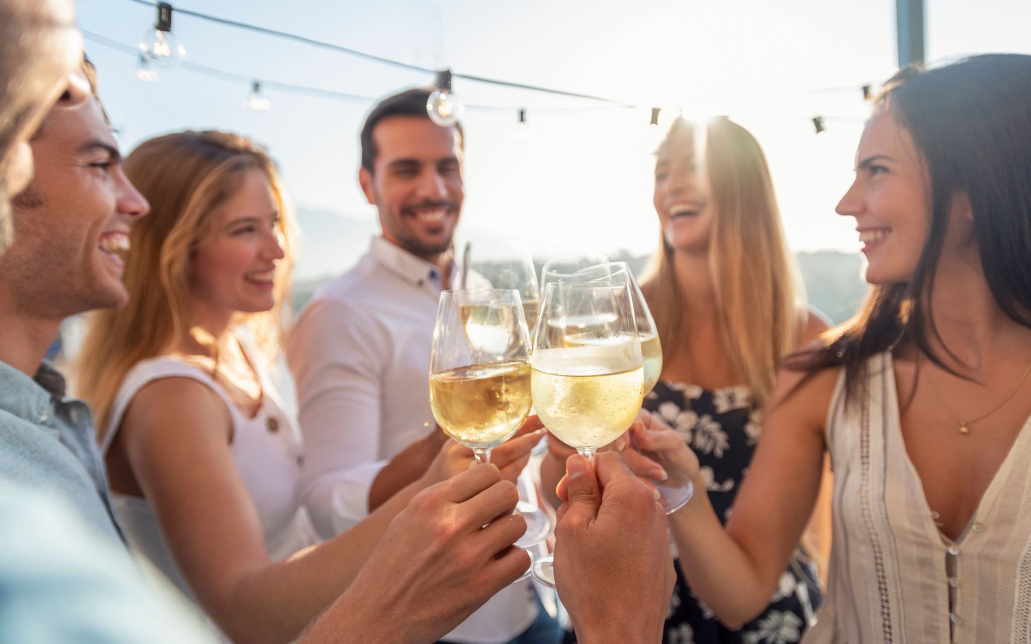 Alkohol bei Hitze: Eine Gruppe von jungen Menschen trinkt Alkohol in der Sonne