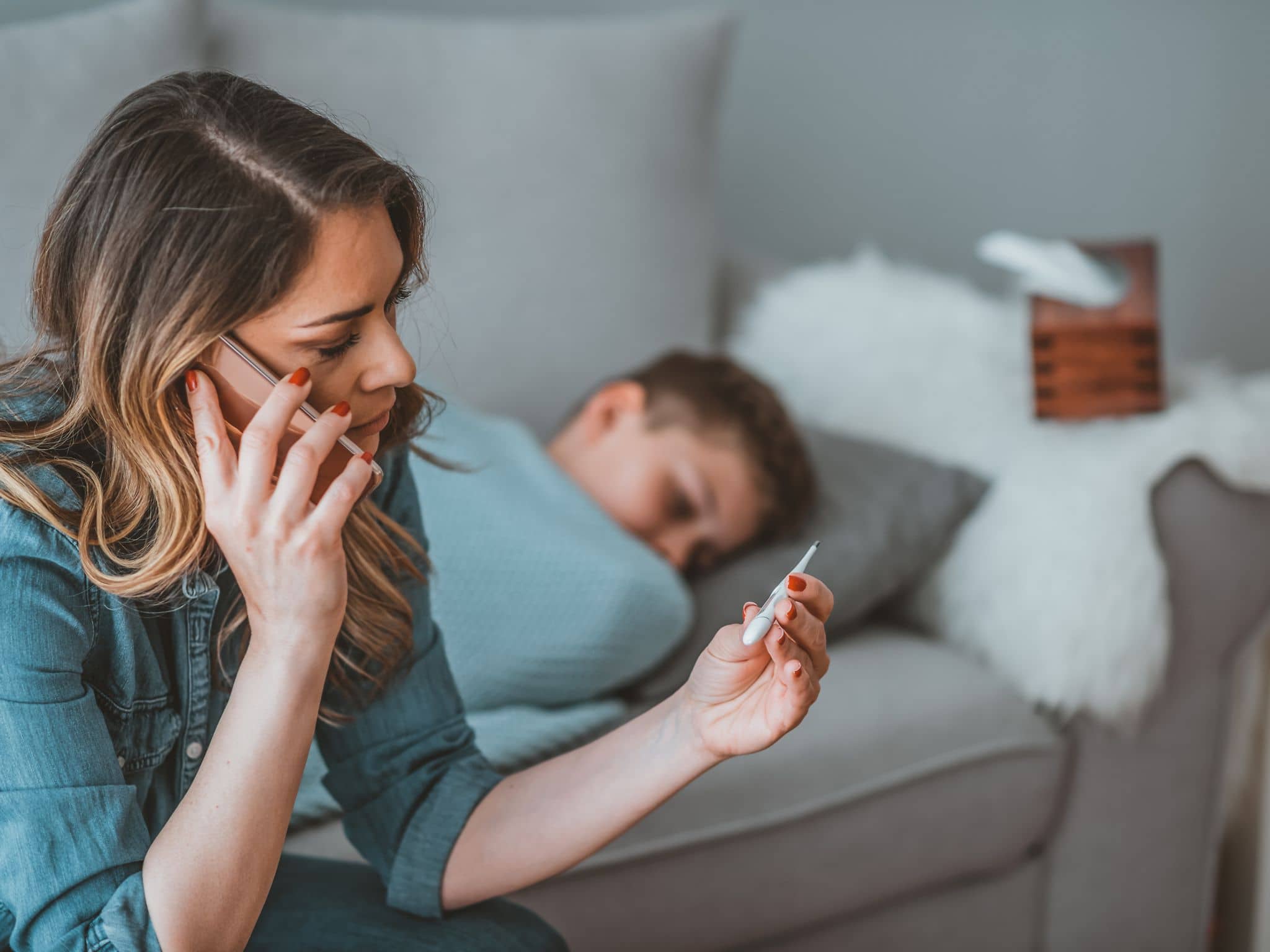 Eine Mutter ruft mit dem Handy den Giftnotruf für Vergiftungen bei Kindern an.