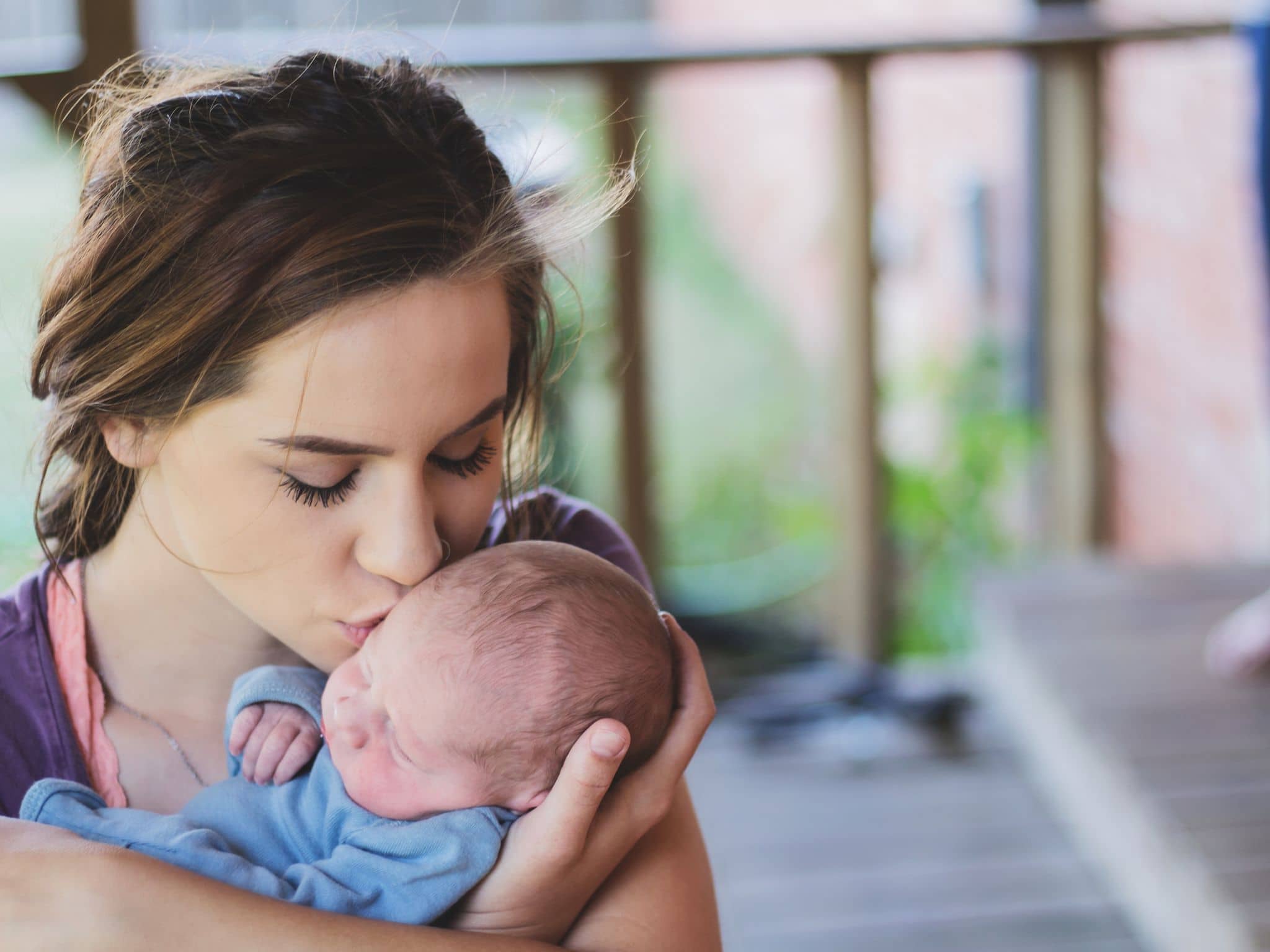 Unbemerkt schwanger: Eine junge Mutter hält ein Baby auf dem Arm