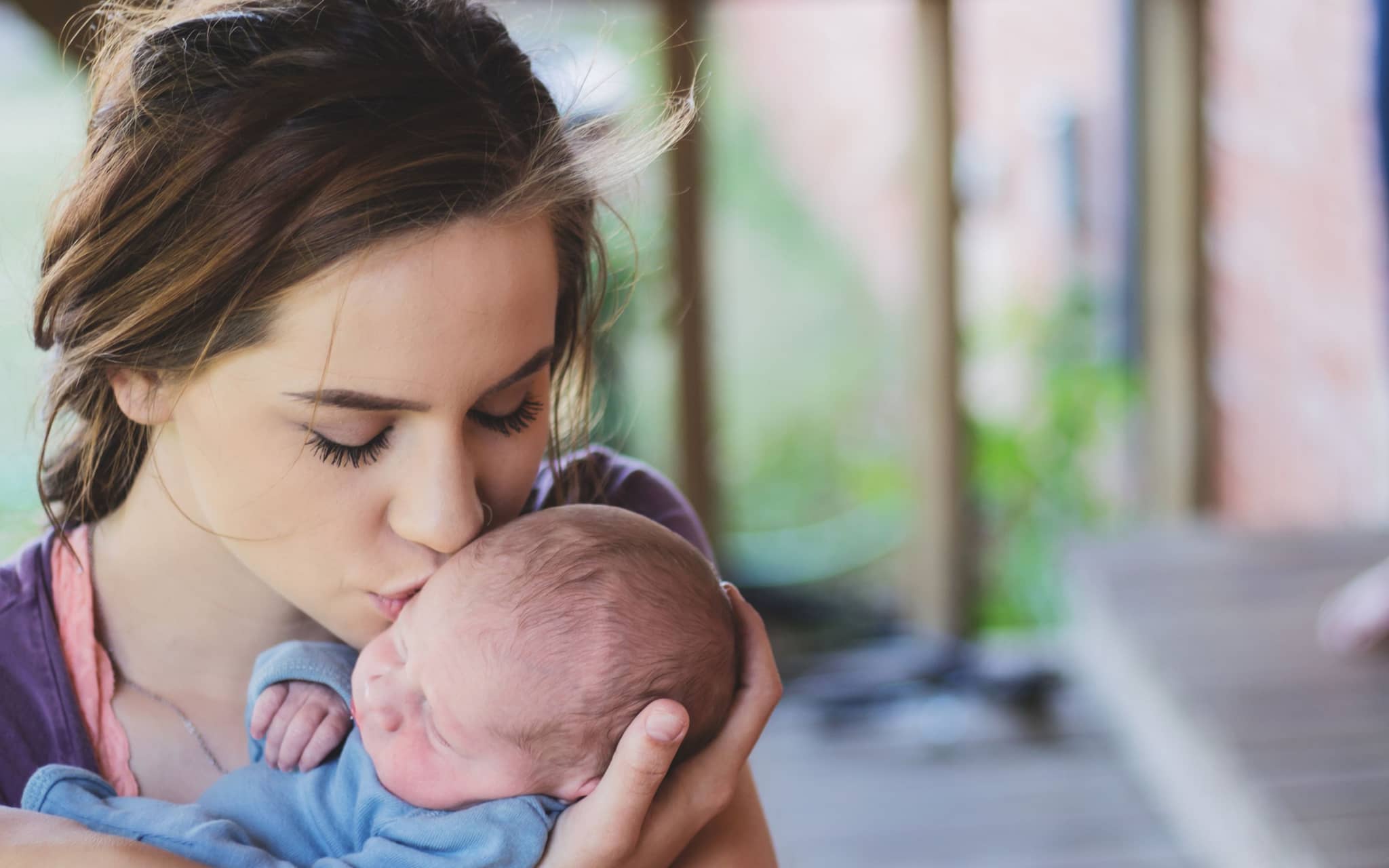 Unbemerkt schwanger: Eine junge Mutter hält ein Baby auf dem Arm