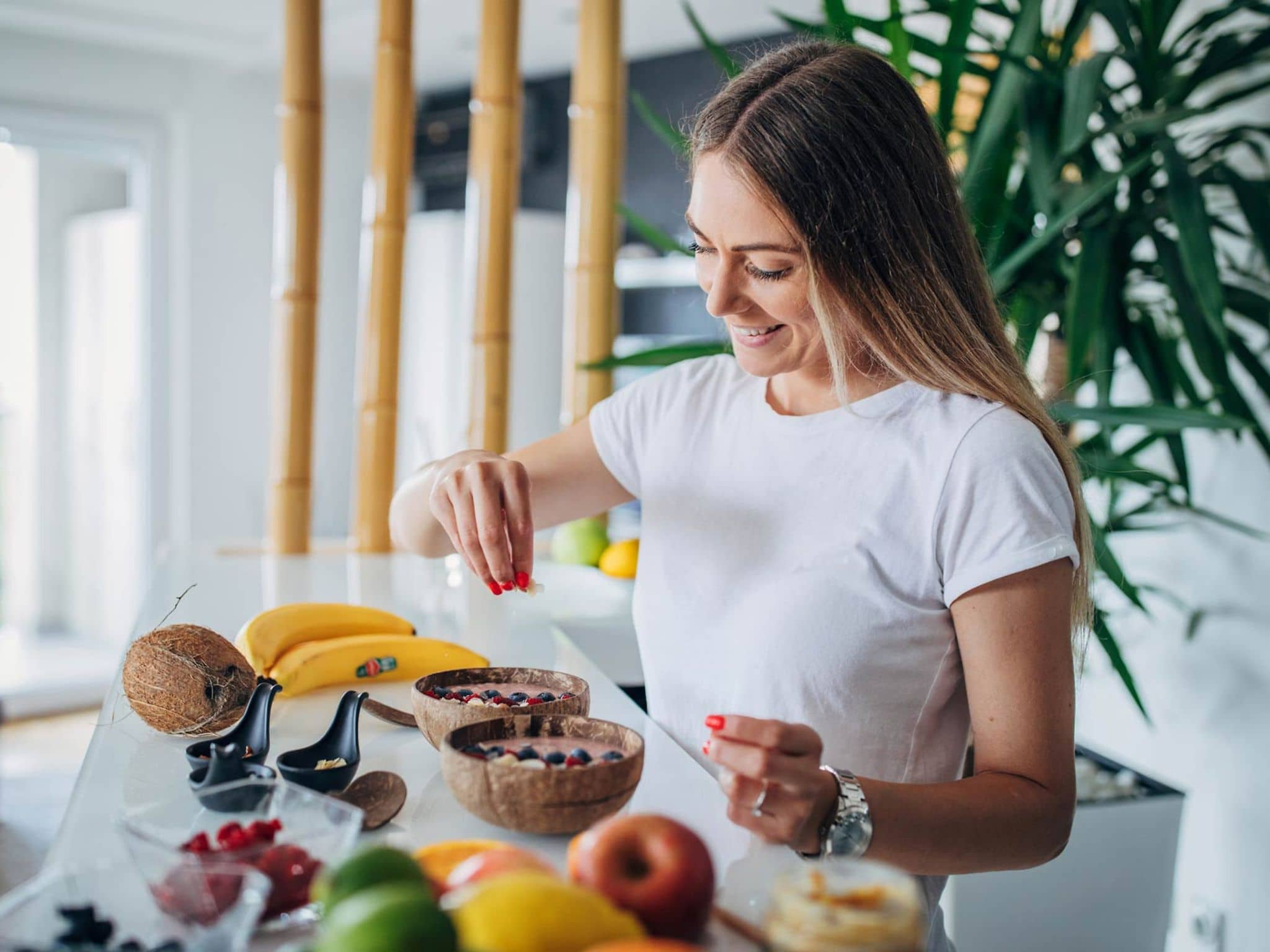 Superfood: Junge Frau bereitet sich in ihrer Küche ein Müsli mit gesunden Zutaten zu.