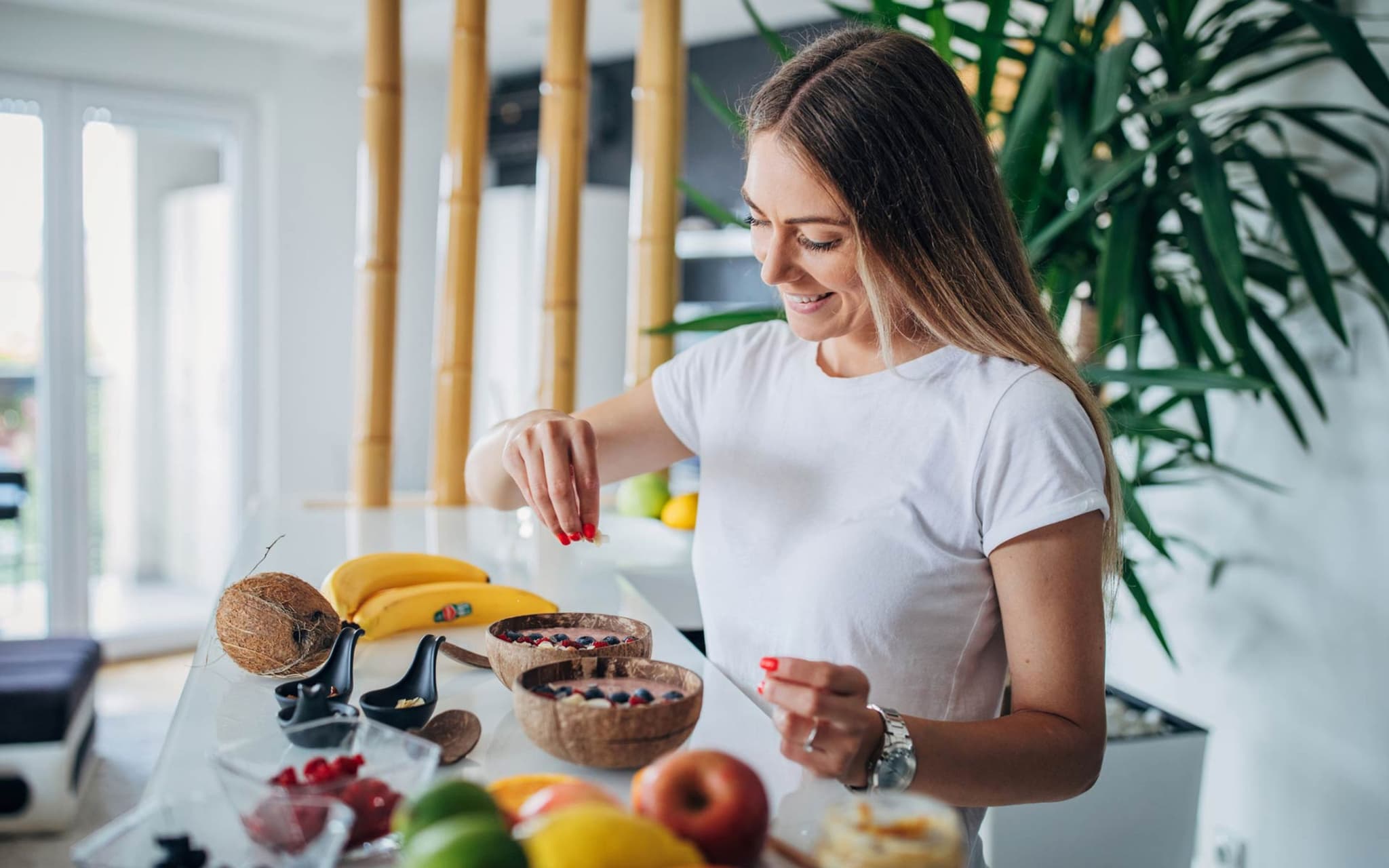 Superfood: Junge Frau bereitet sich in ihrer Küche ein Müsli mit gesunden Zutaten zu.