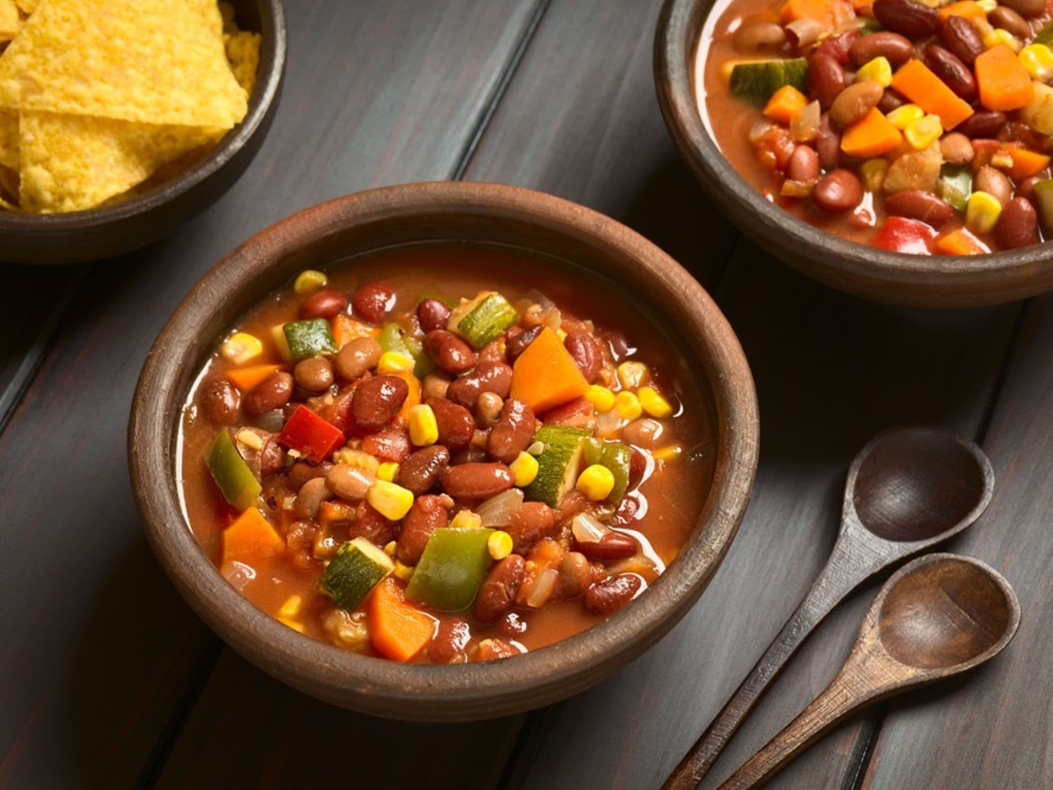 Chili sin carne in zwei braunen Schüsseln angerichet.