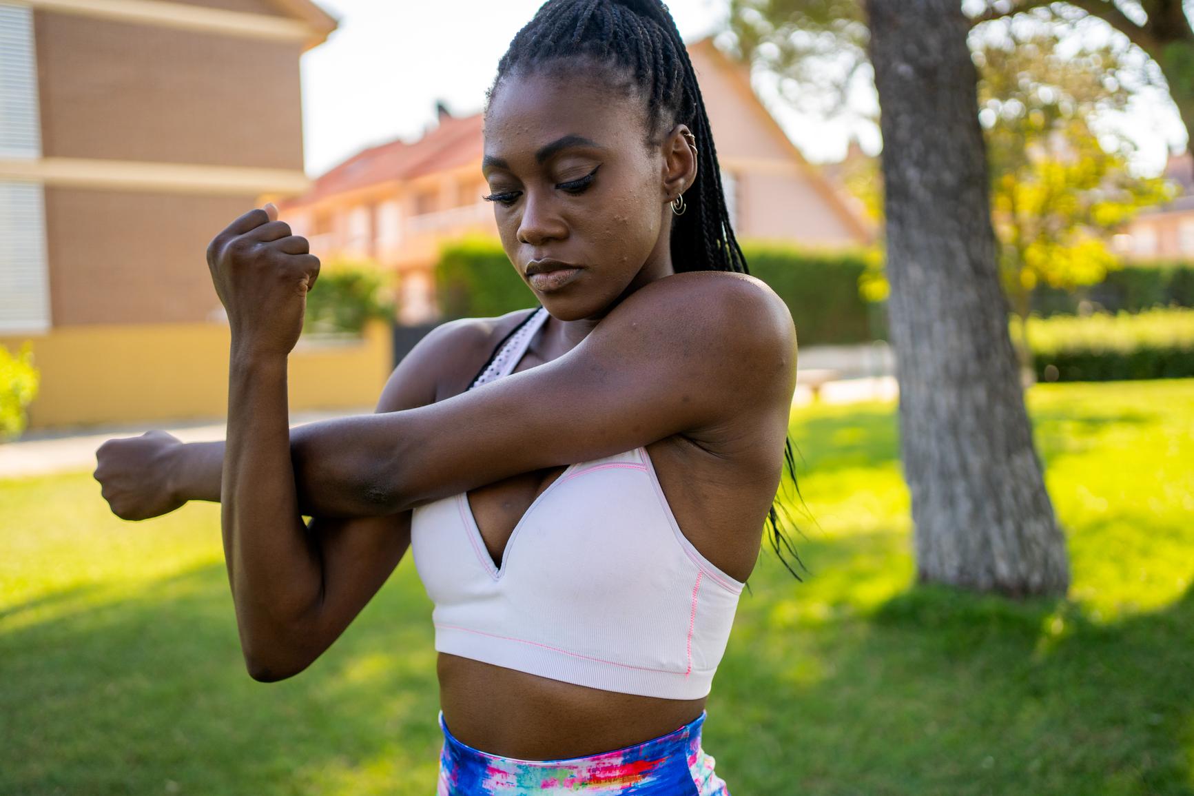 Tipps gegen Muskelkater: Frau in Soortkleidung dehnt ihren Arm
