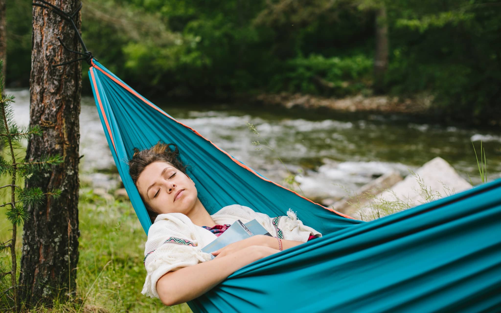 Regeneration: Junge Frau schläft in Hängematte