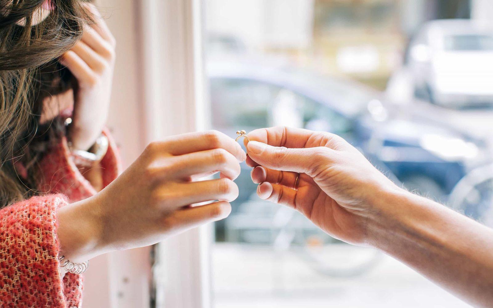 Kontaktallergie: Eine Frauenhand und eine Männerhand halten gemeinsam einen Ring.