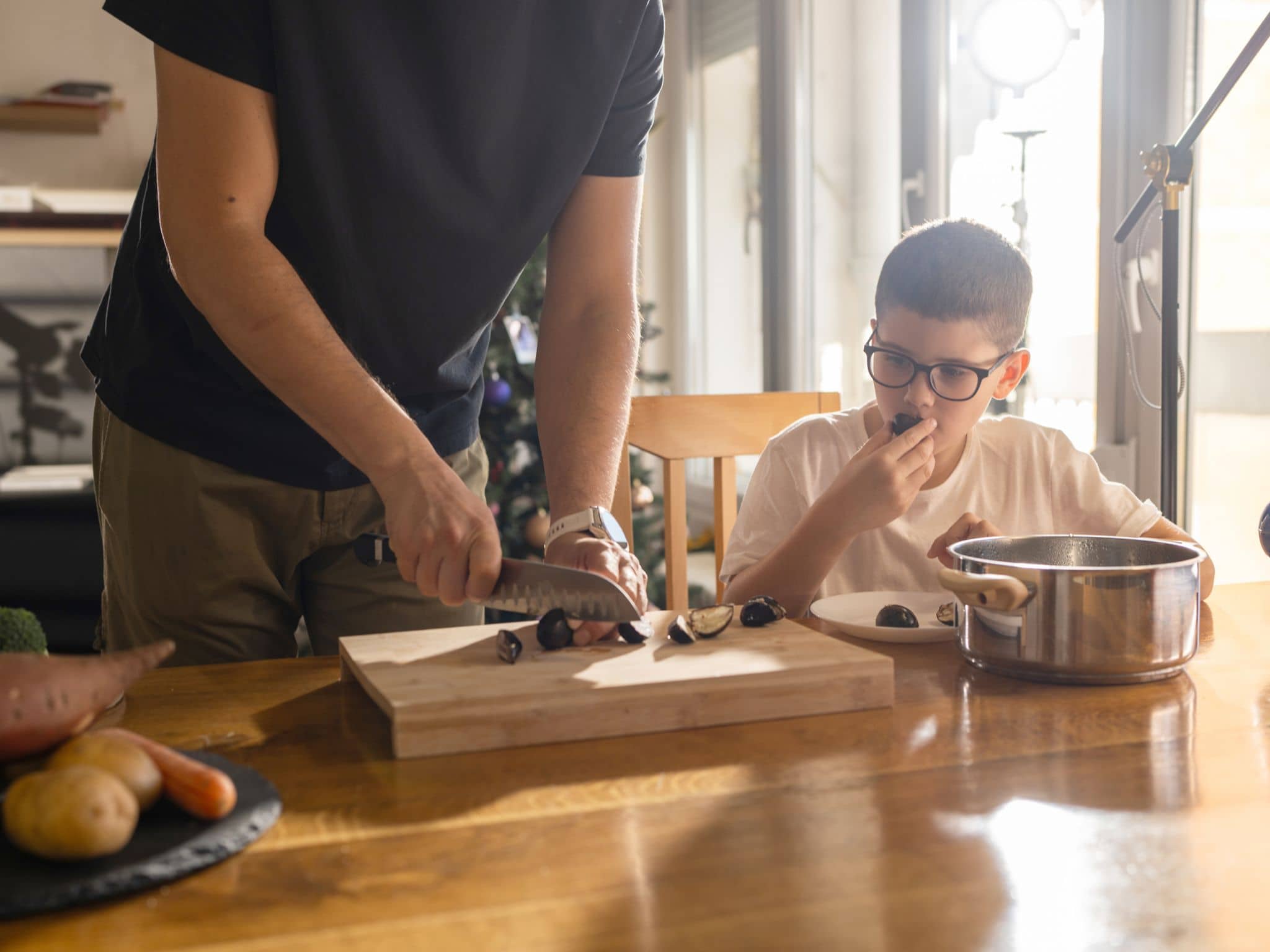 Vater und Sohn bereiten gemeinsam gesunde Maronen zu.