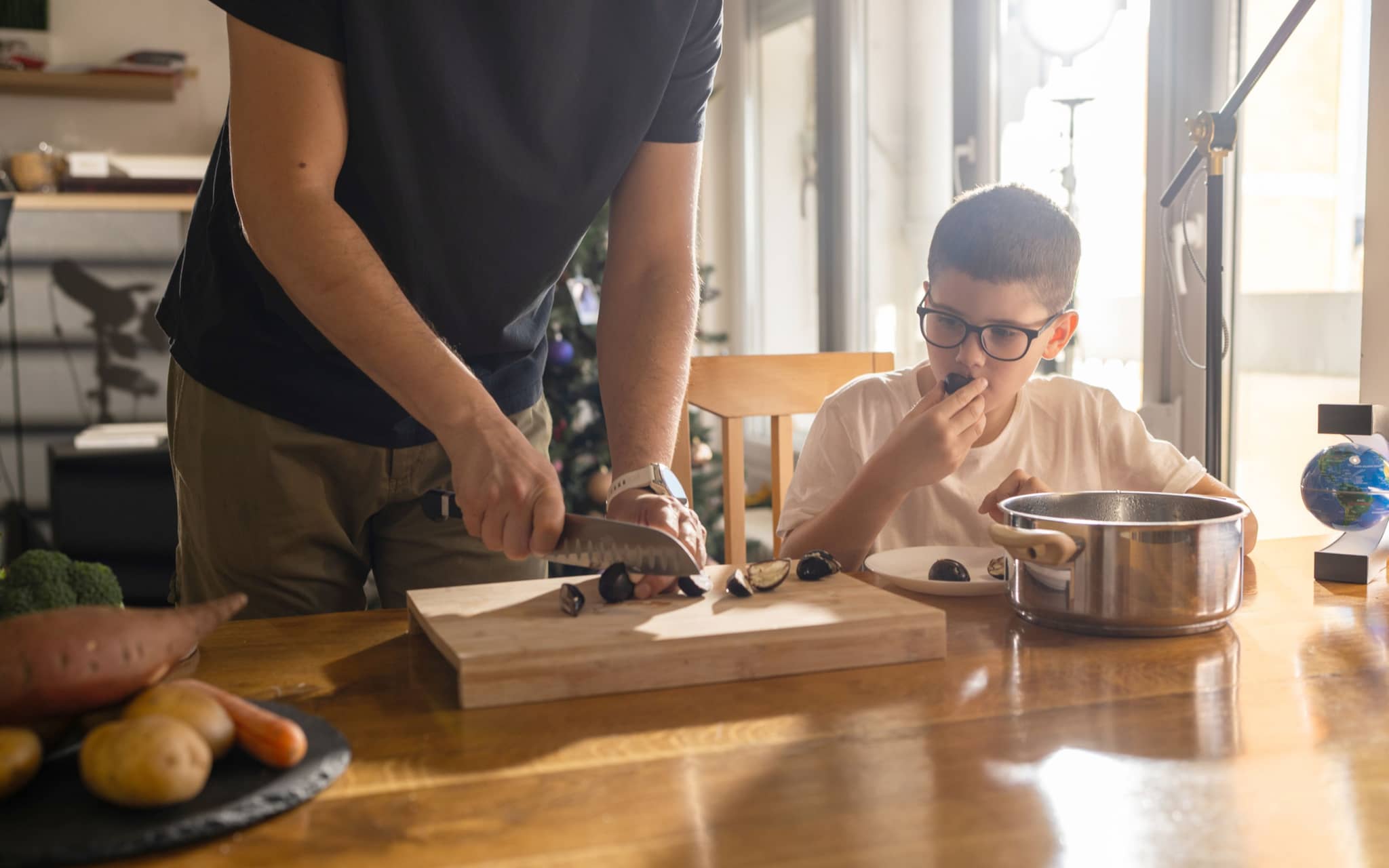 Vater und Sohn bereiten gemeinsam gesunde Maronen zu.