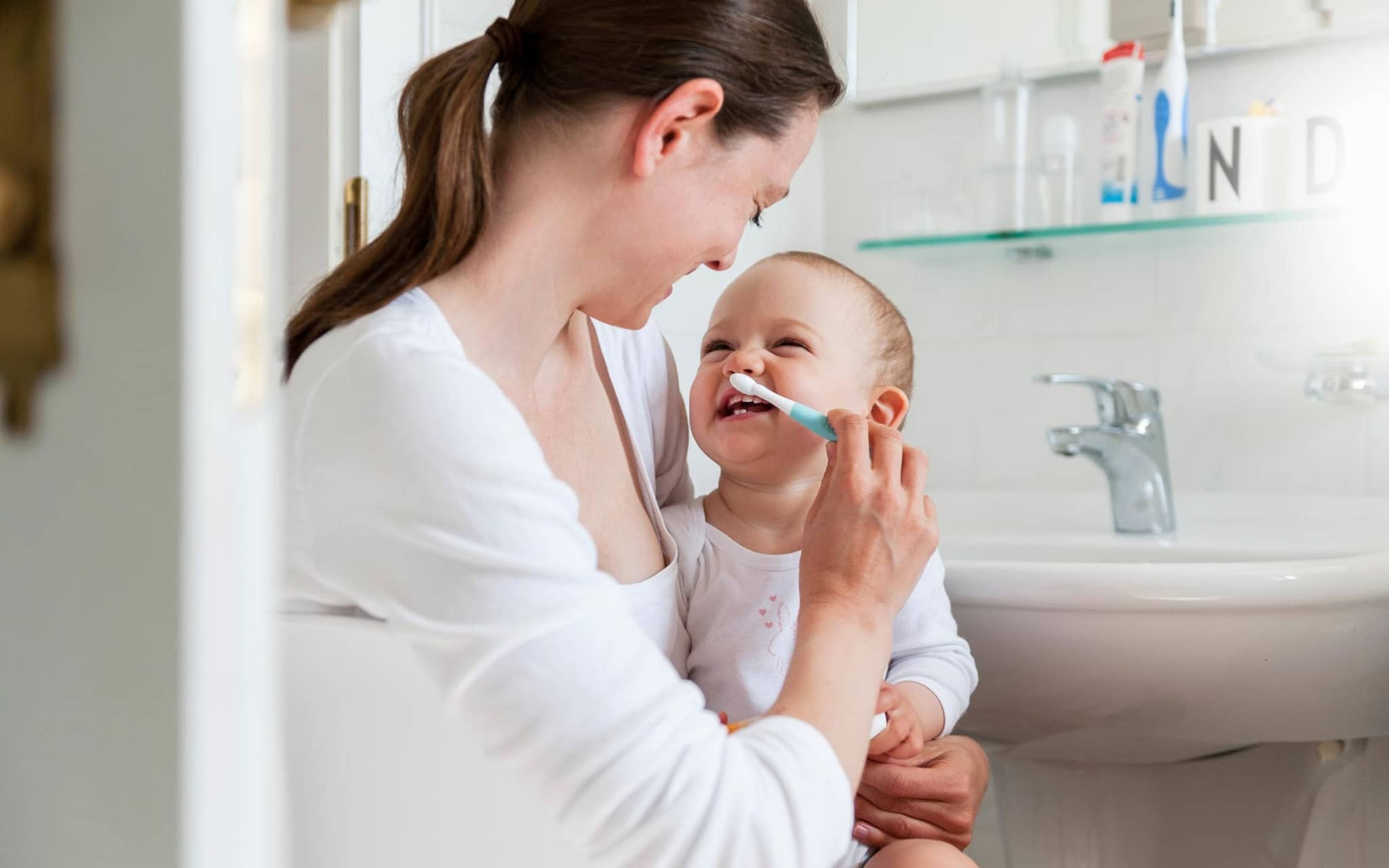 Zahnpflege bei Babys: Eine Mutter putzt die Zähne ihres Kleinkinds.