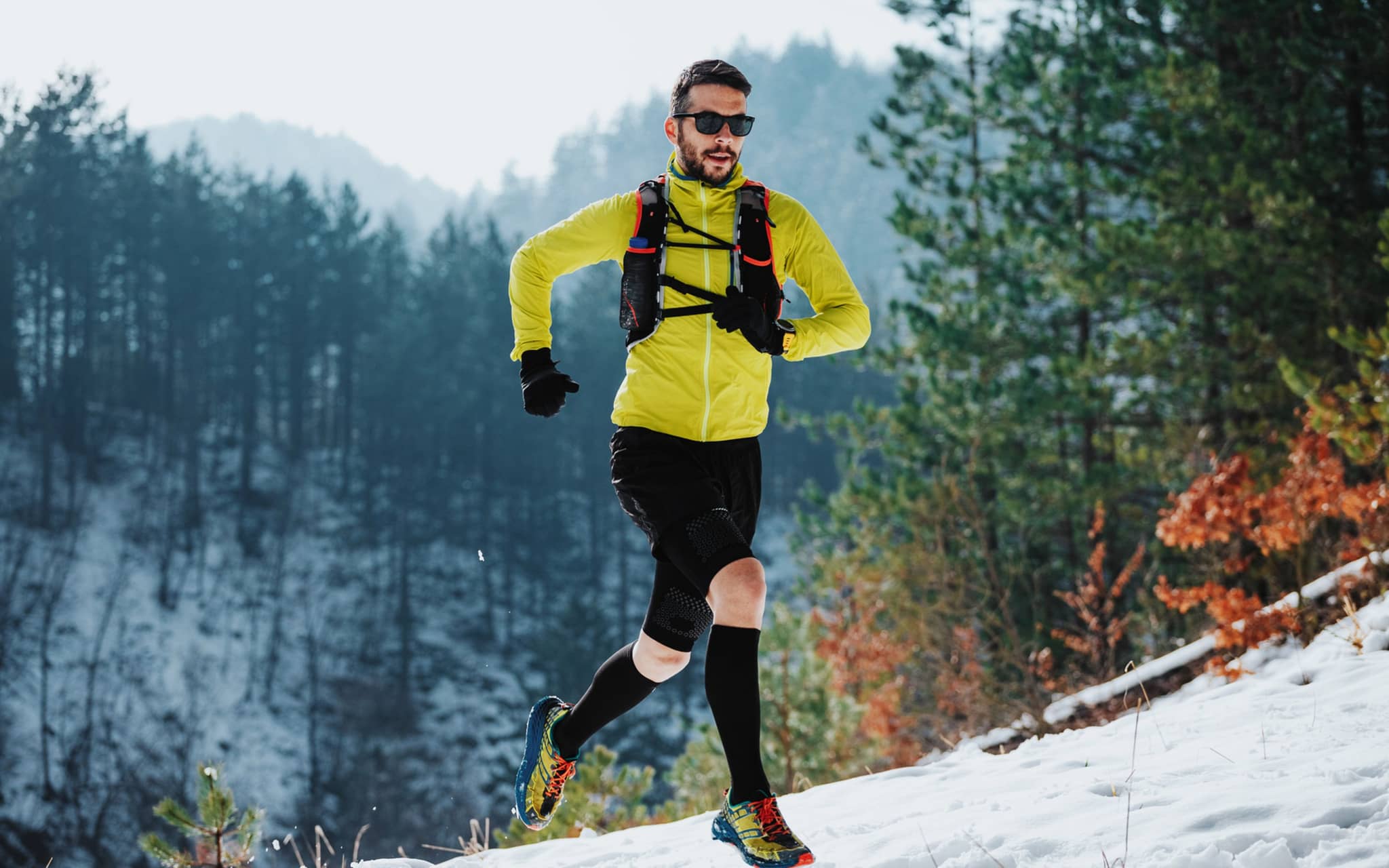 Sport im Winter: Ein Läufer auf einem verschneiten Trail in den Bergen