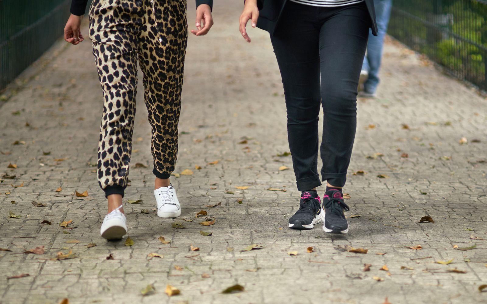Schritte pro Tag: Ausschnitt der Beine zweier Menschen, die nebeneinander laufen