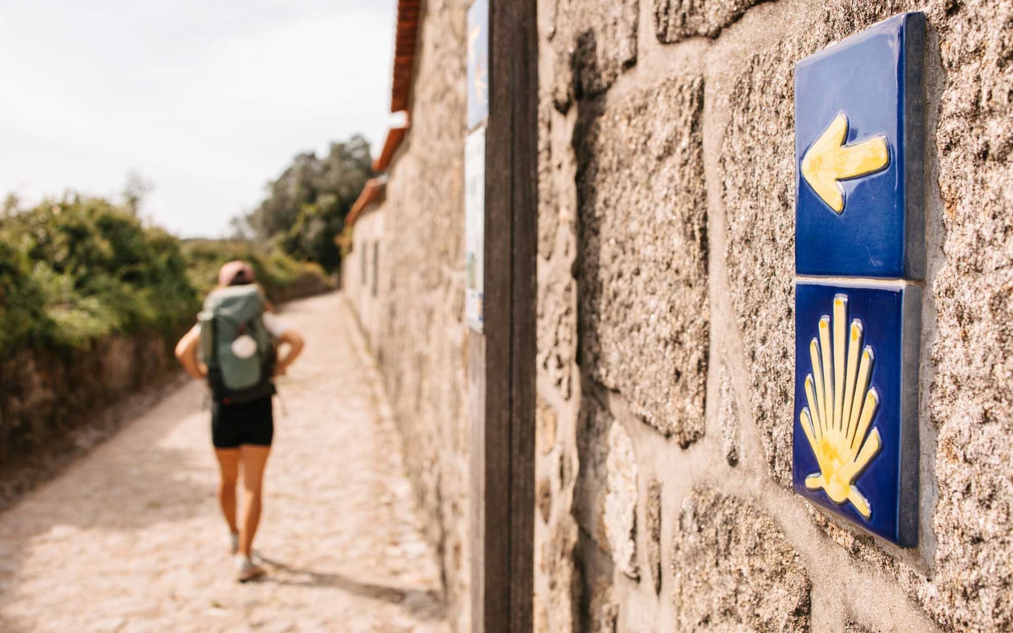 Frau folgt den Schildern auf dem Pilgerweg Santiago de Compostela