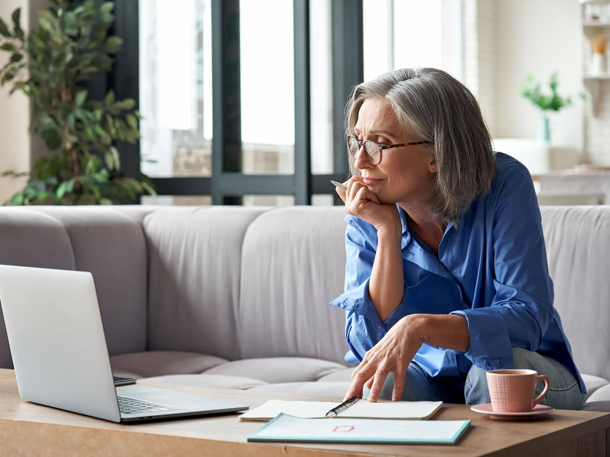Pflegekurse für Angehörige: Reifere Frau sitzt am Laptop und nimmt an einer Online-Schulung teil