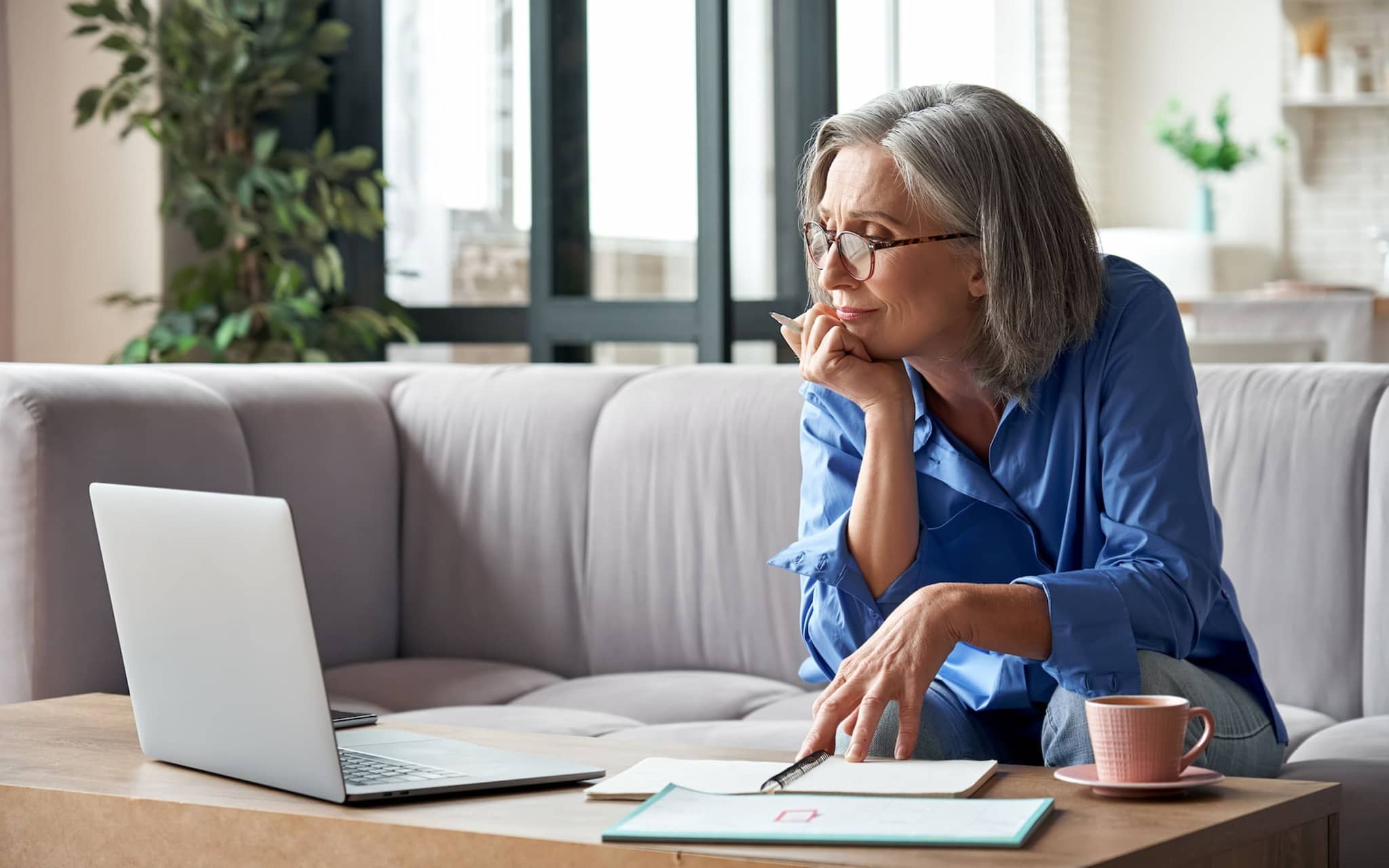 Pflegekurse für Angehörige: Reifere Frau sitzt am Laptop und nimmt an einer Online-Schulung teil