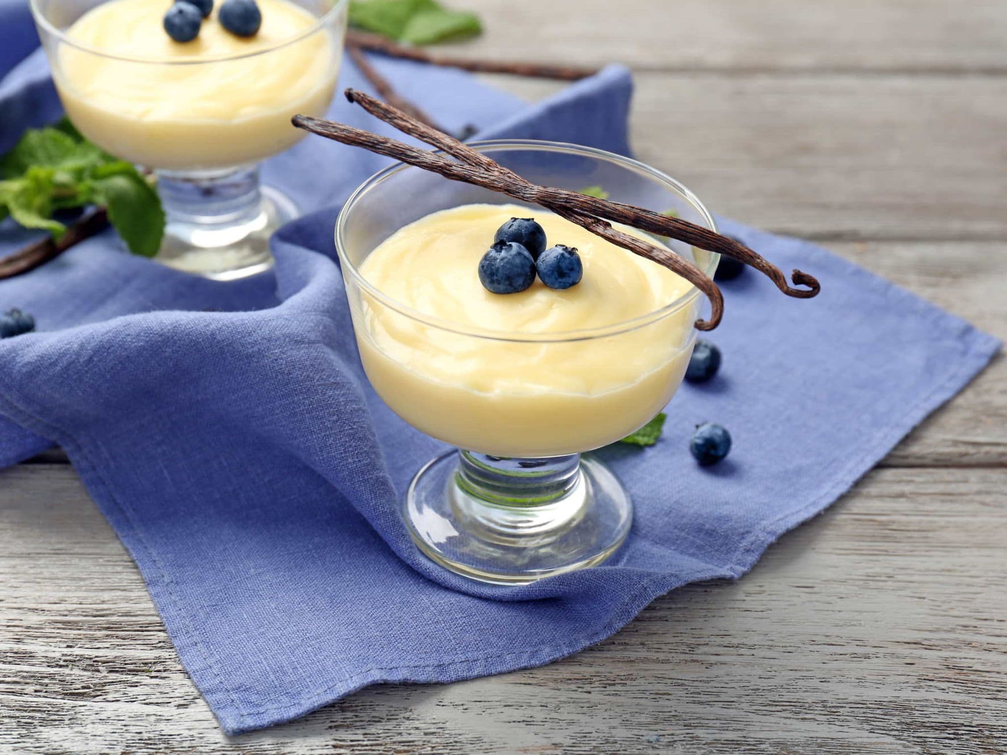 Vanillepudding ohne Instandpulver: zwei angerichtete Glasschälchen mit Pudding und Blaubeeren