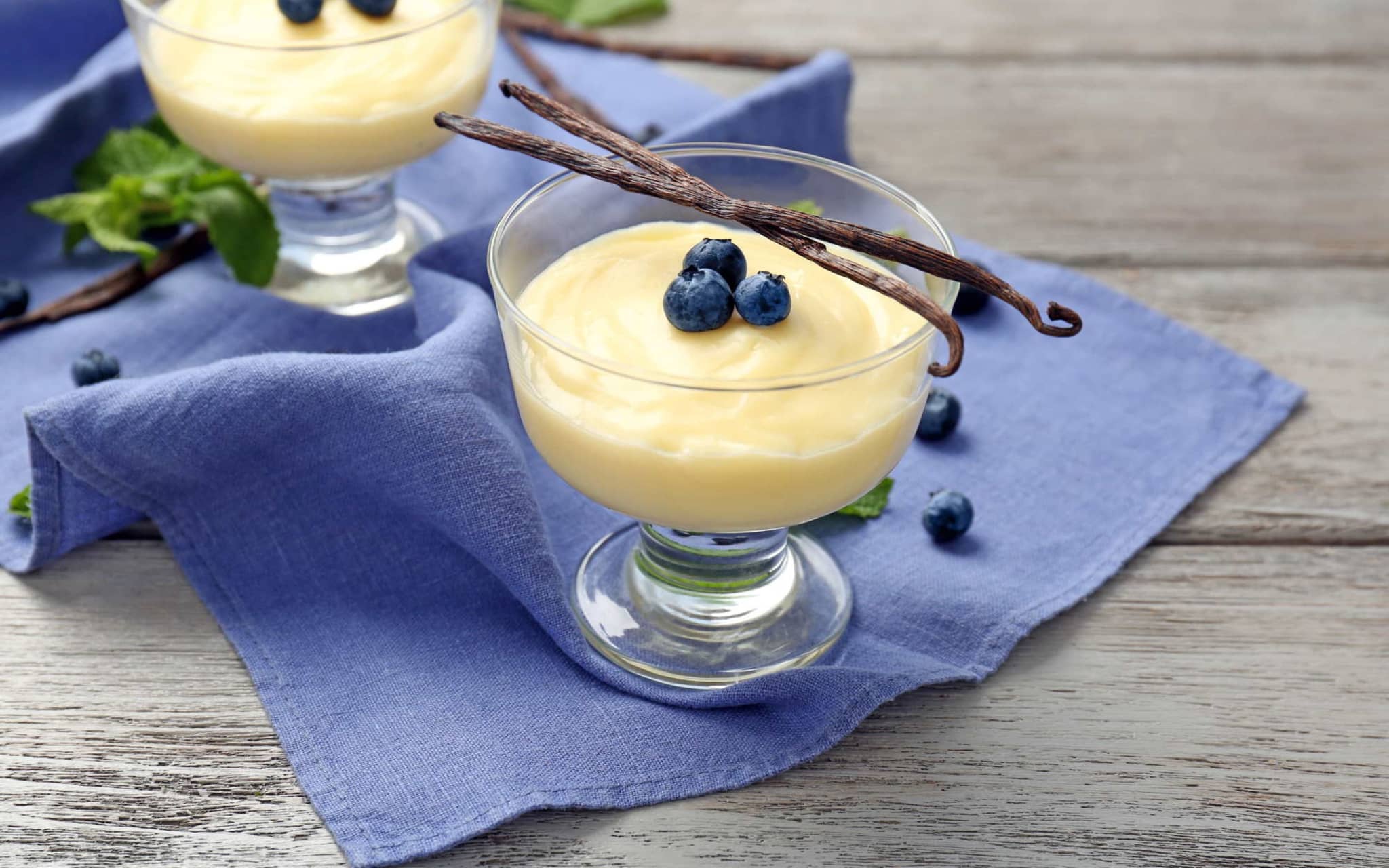 Vanillepudding ohne Instandpulver: zwei angerichtete Glasschälchen mit Pudding und Blaubeeren