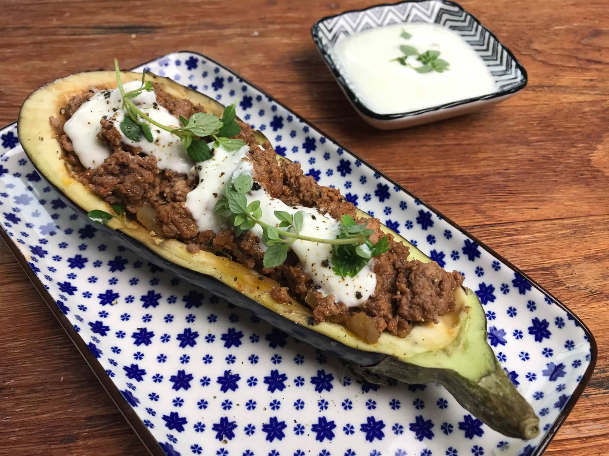 Gefüllte Aubergine: Eine auf einer Servierplatte angerichtete Aubergine