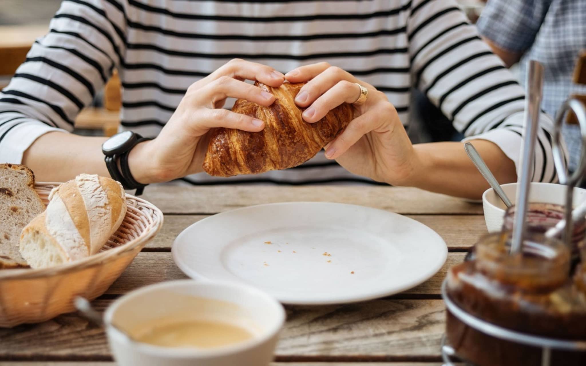 Diabetes mellitus Typ1: Frau hält ein Crossaint in den Händen.