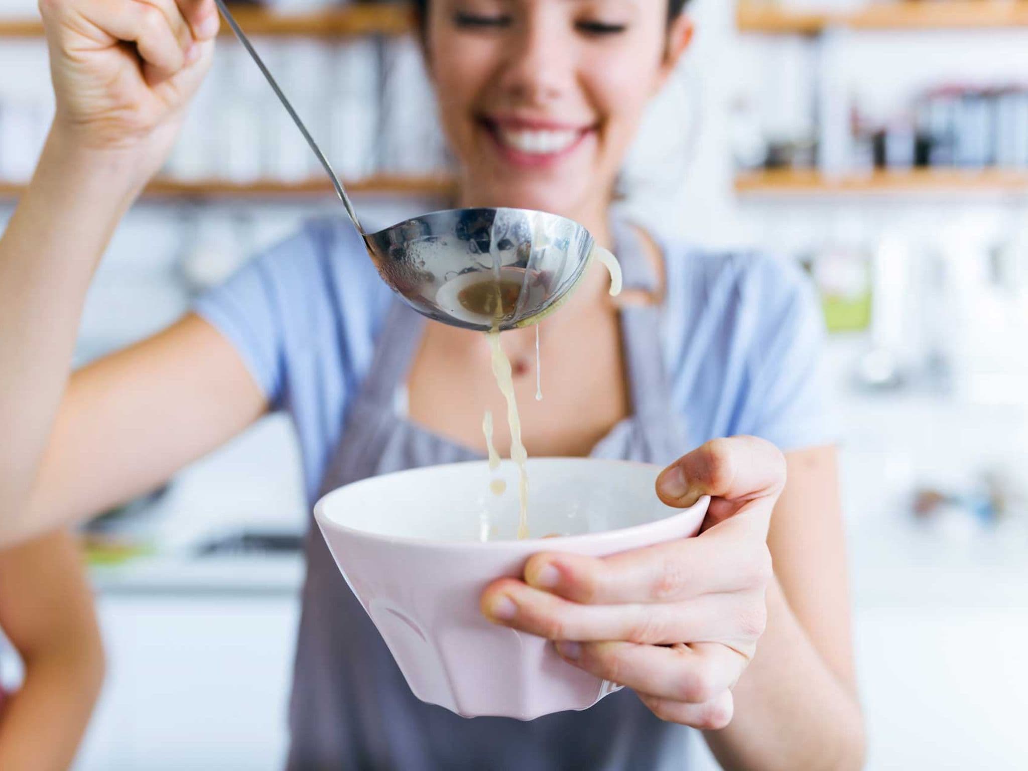 Frau füllt Suppe in eine Schüssel