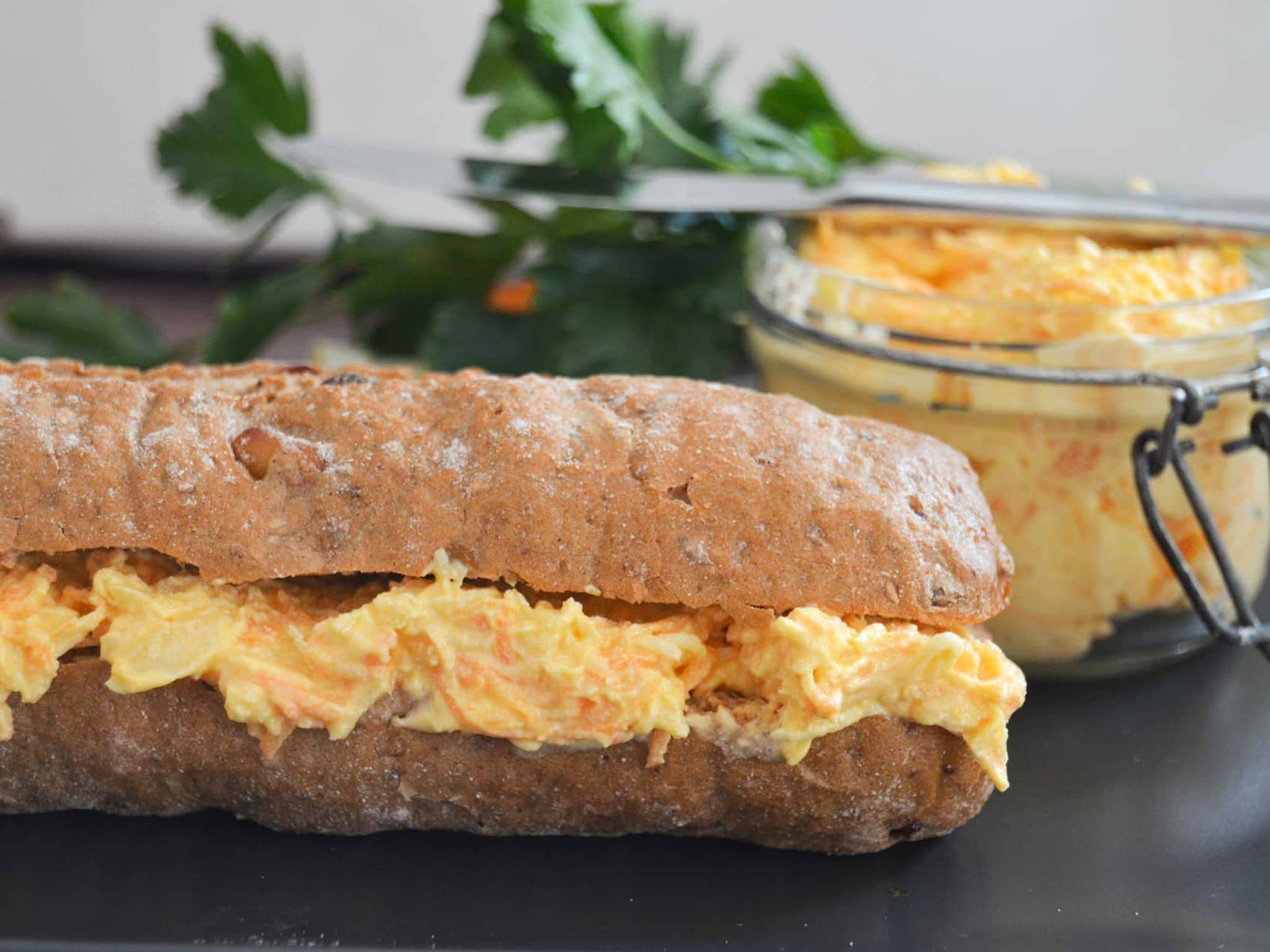 Vegetarischer Möhren-Apfel-Aufstrich auf einem dunklen Baguette