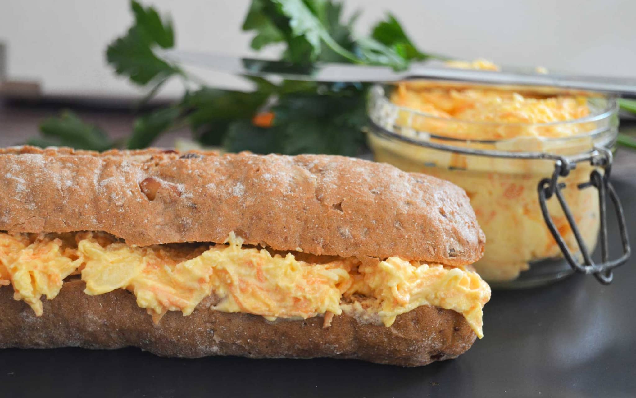 Vegetarischer Möhren-Apfel-Aufstrich auf einem dunklen Baguette
