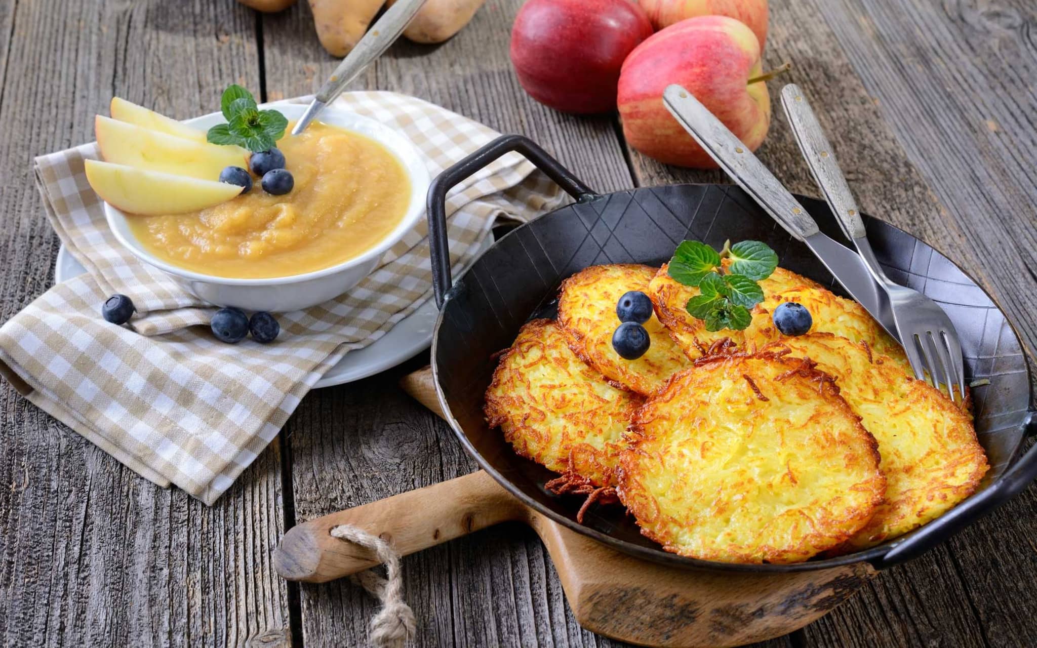 Kartoffelpuffer im Pfännchen, daneben eine Schale mit Apfelmus