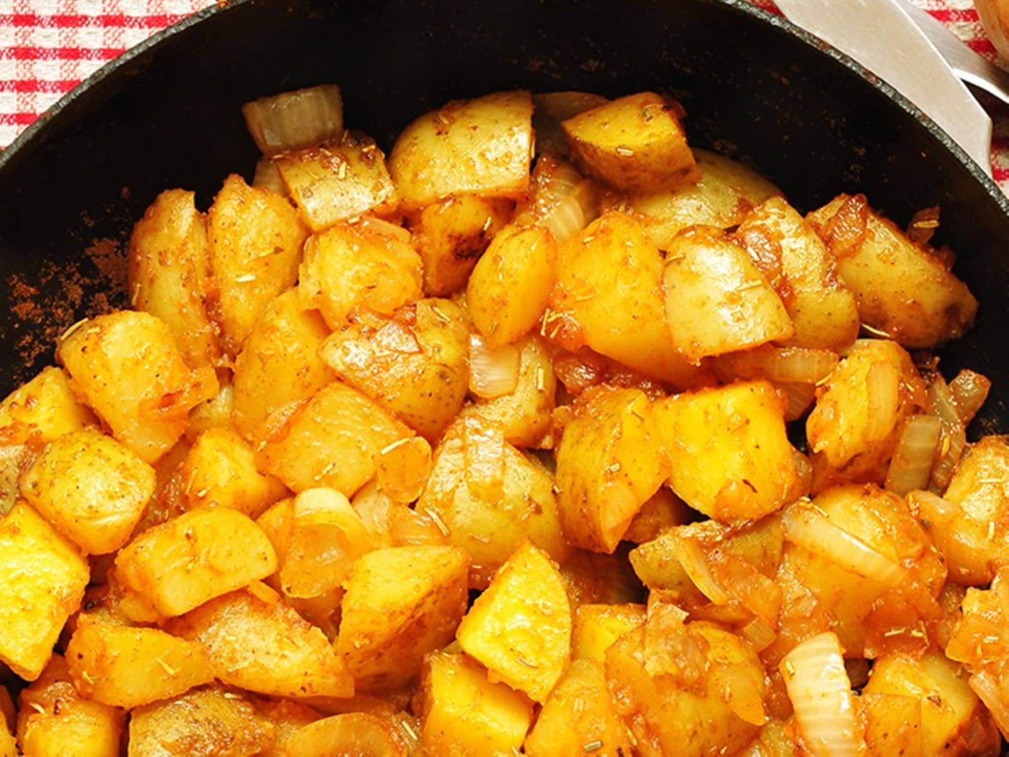 Leckere Bratkartoffeln mit Zwiebeln in einer Pfanne.