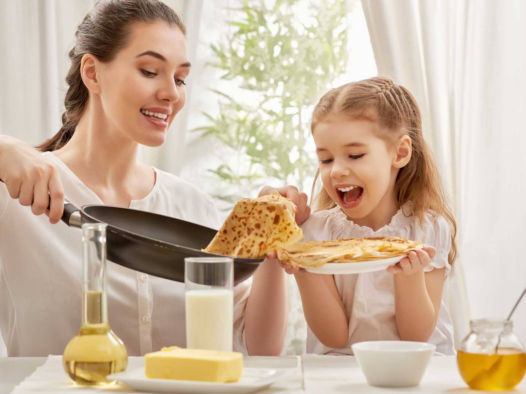 Mutter und Tochter backen Pfannkuchen