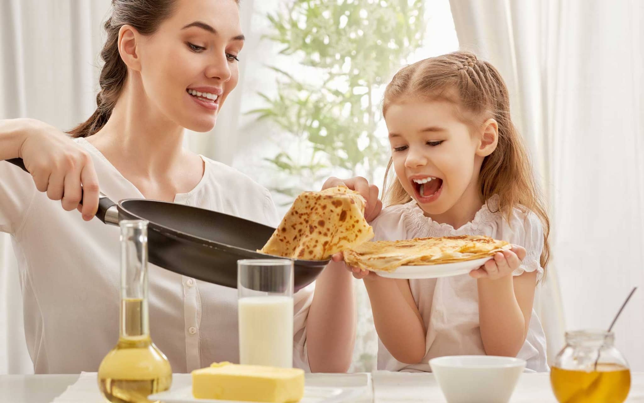 Mutter und Tochter backen Pfannkuchen
