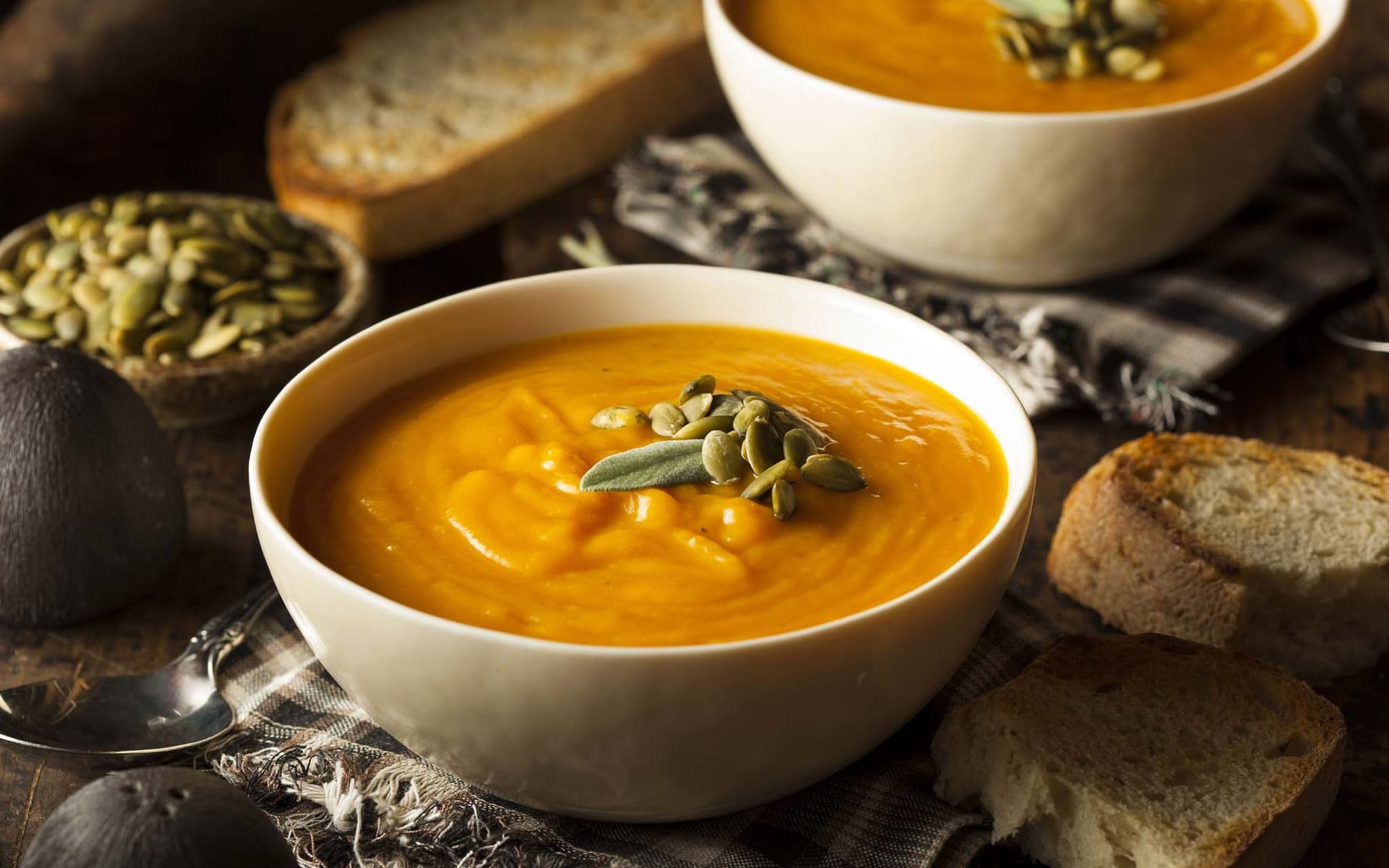 Rezeptfoto: Auf einem rustikalen Tisch steht eine spanische Tortilla in einer Tonform.