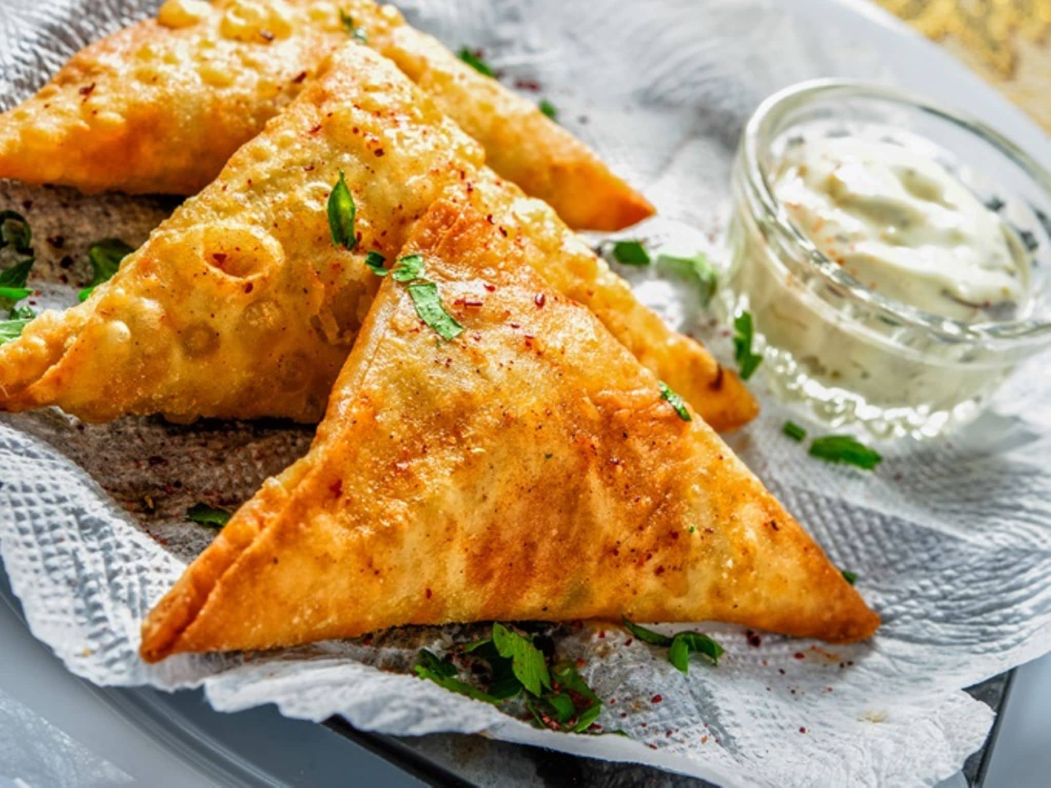 Blätterteigtaschen: Drei Blätterteigtaschen auf einem Teller mit Dip