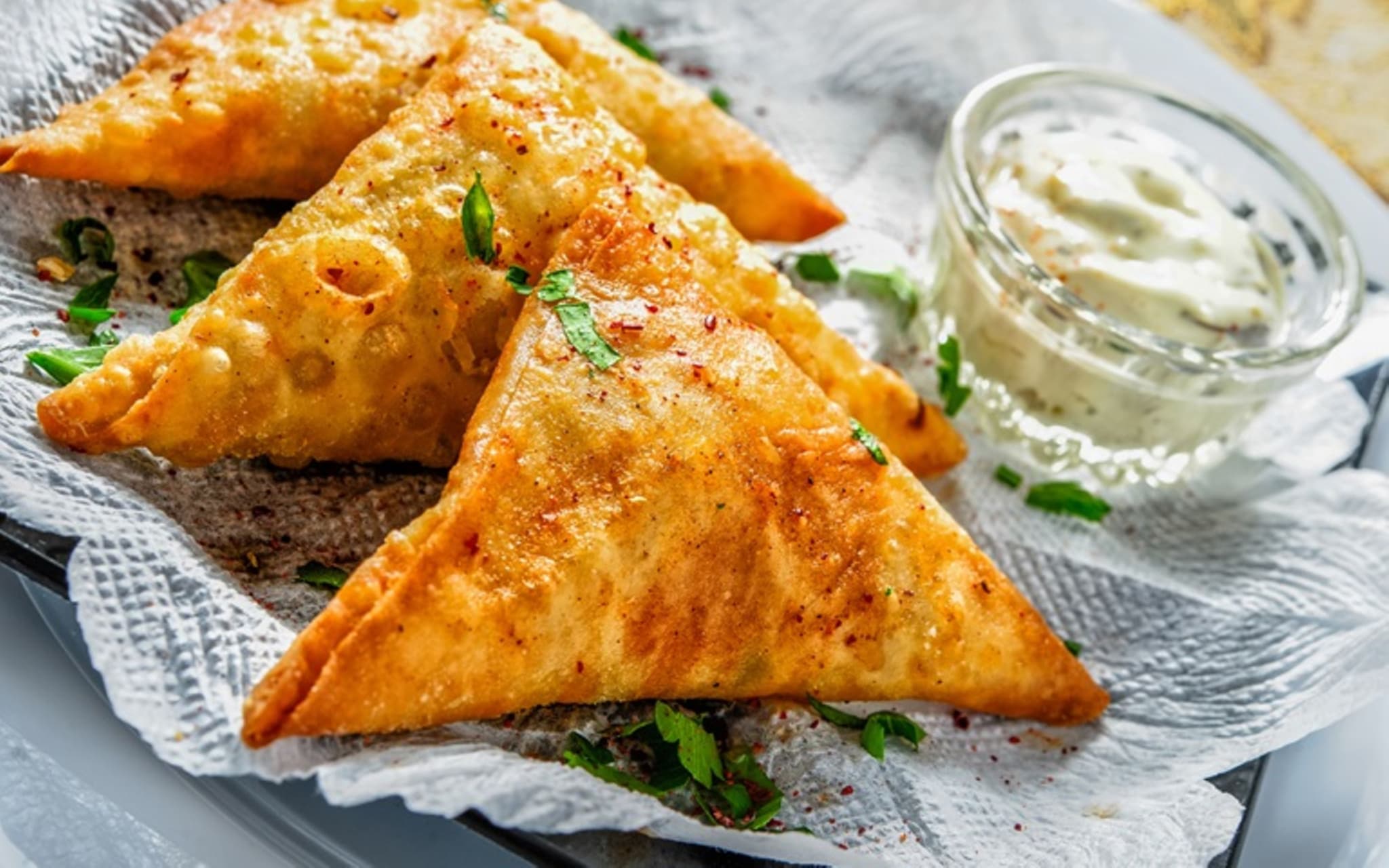 Blätterteigtaschen: Drei Blätterteigtaschen auf einem Teller mit Dip