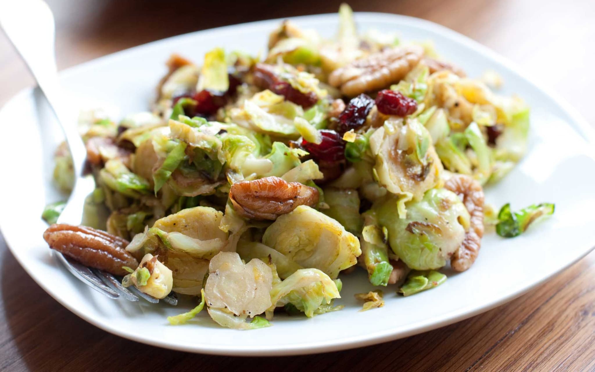 Rosenkohl mit Nüssen und Speck auf einem Teller
