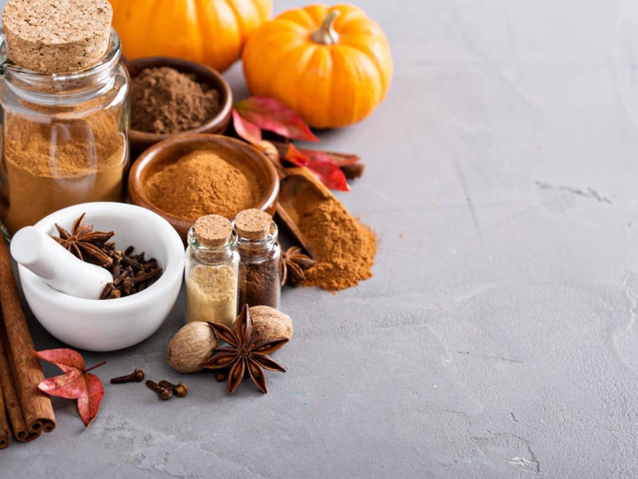 Pumpkin Gewürz: Schüsseln mit Gewürzen unteranderem Nelken und Kürbise im Hintergrund.
