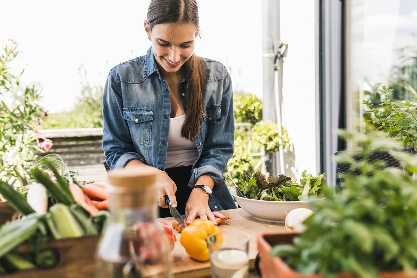 Junge Frau bereitet sich ihr Low-Carb-Essen zu, bestehend aus viel Grün.