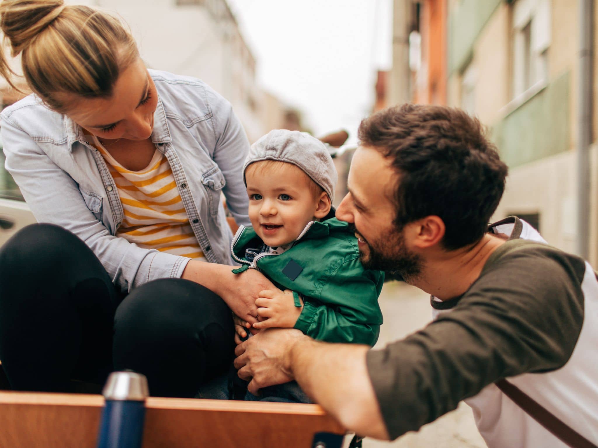 Cuplu tânăr privind cu bucurie spre copilul lor mic.