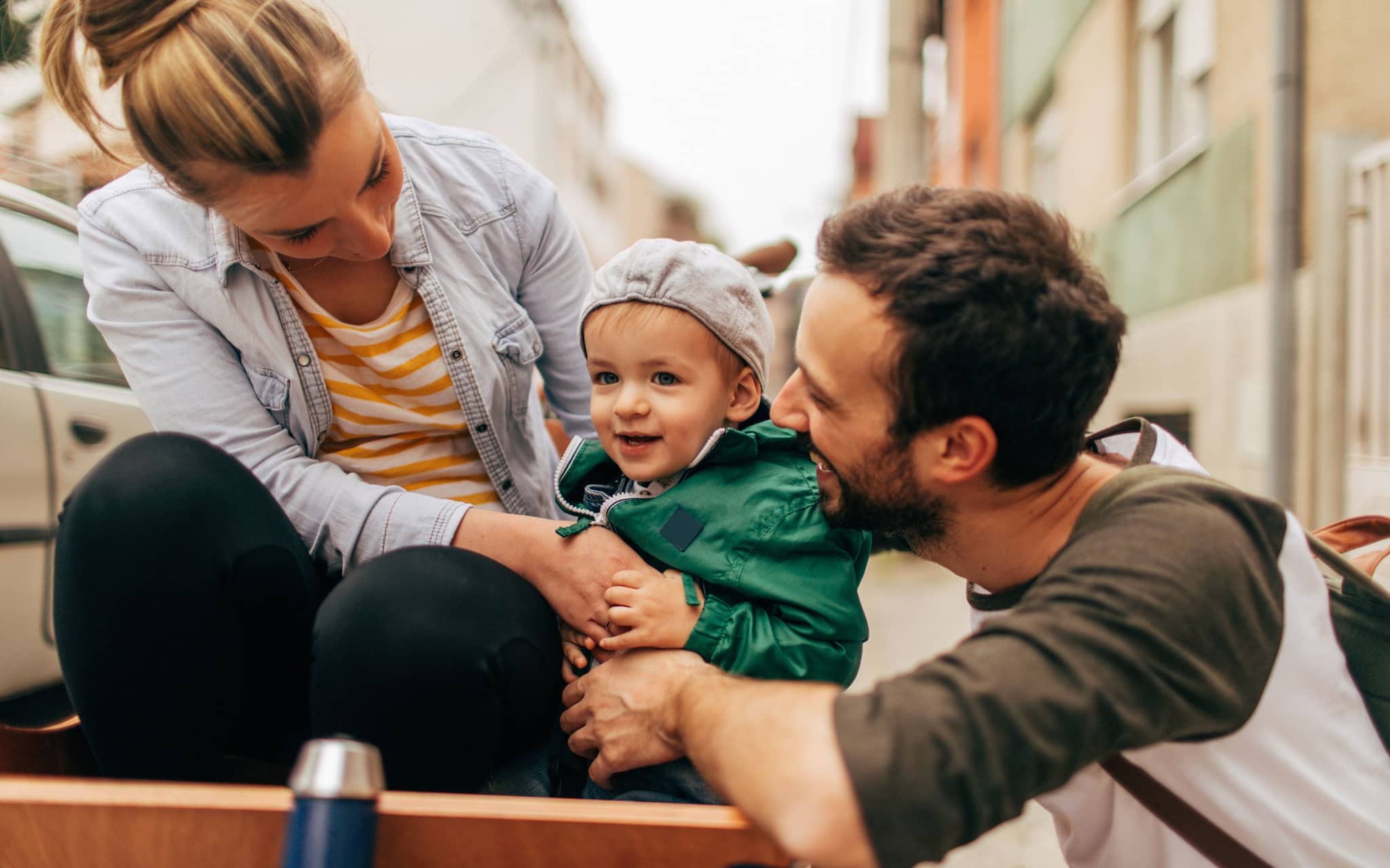Cuplu tânăr privind cu bucurie spre copilul lor mic.