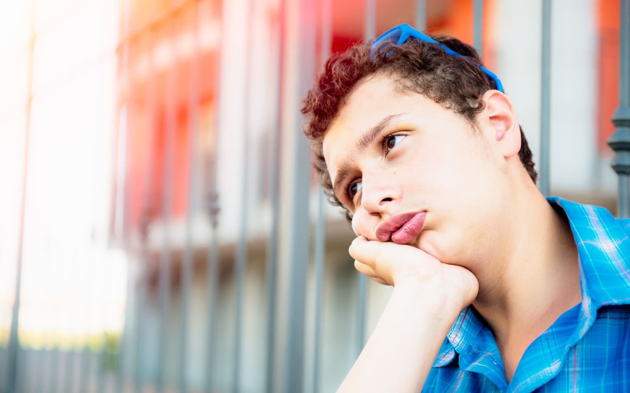 Testosteronmangel: Ein Junge im Teenageralter sitzt gelangweilt vor einer Wand und träumt