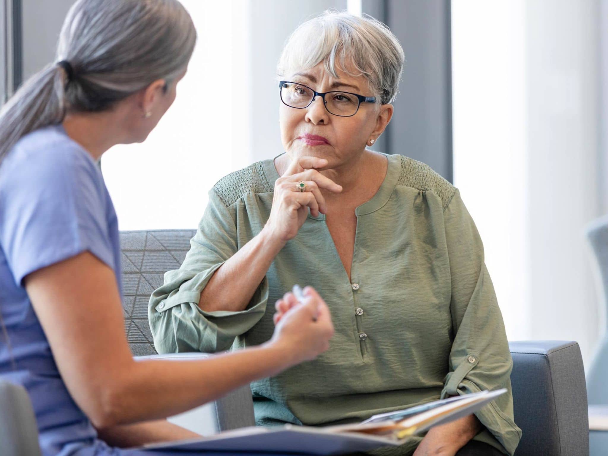 Gender Health Gap: Eine Ärztin unterhält sich mit einer älteren Patientin.