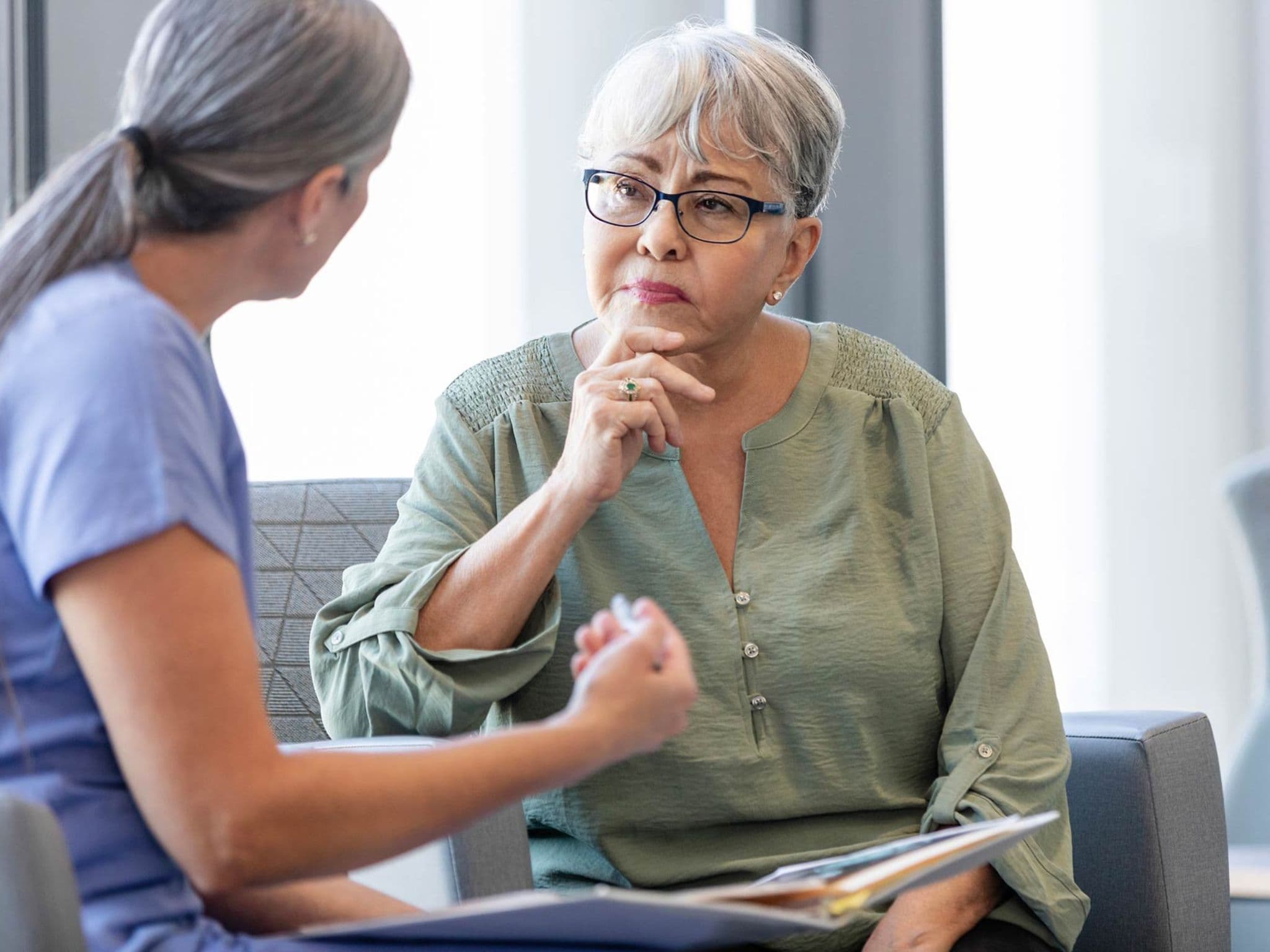 Gender Health Gap: Eine Ärztin unterhält sich mit einer älteren Patientin.
