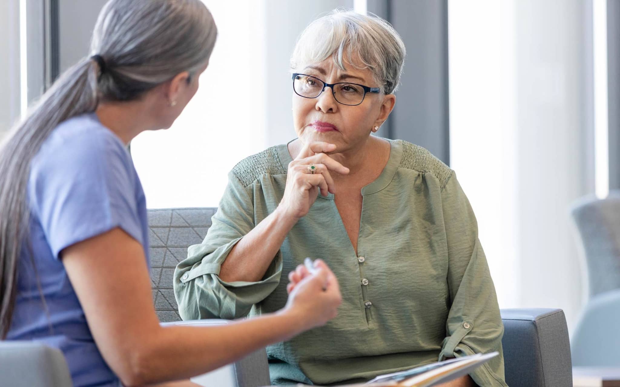 Gender Health Gap: Eine Ärztin unterhält sich mit einer älteren Patientin.