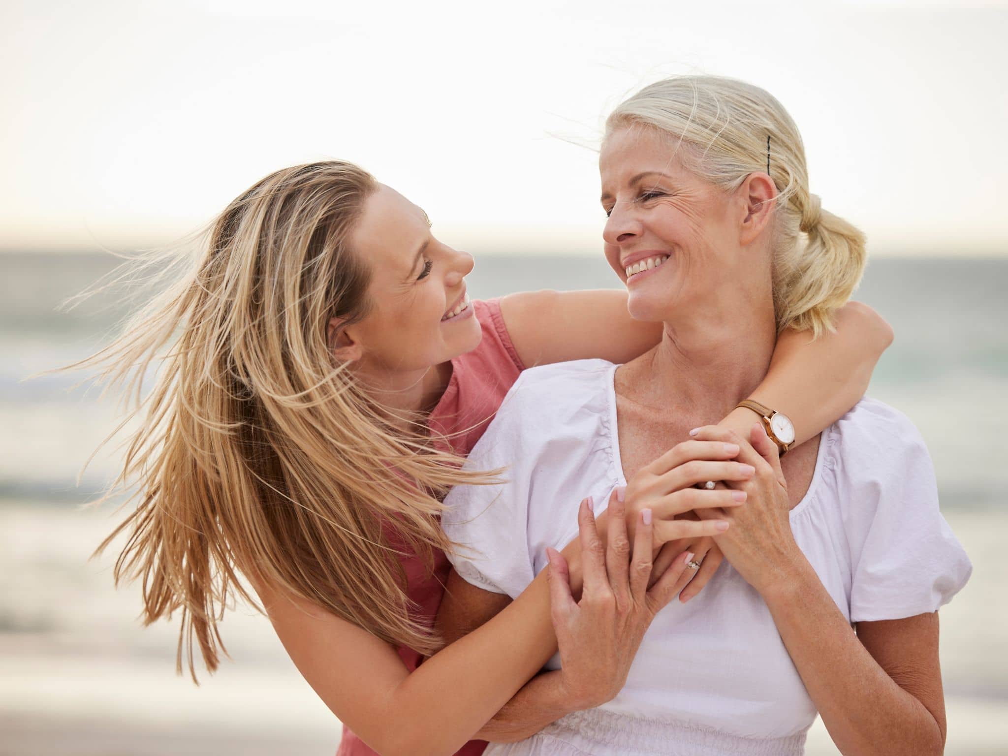 Vulva-Entwicklung: Eine Mutter umarmt ihre Tochter am Strand