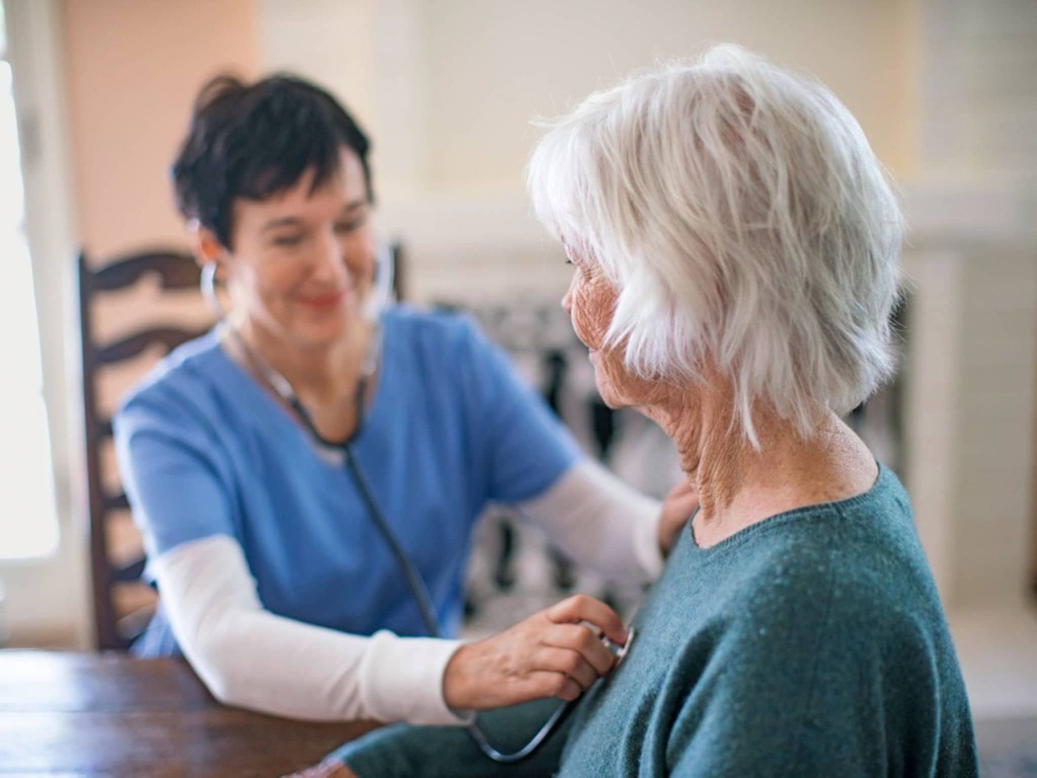 Vorsorge Hypertonie: Ältere Dame wird von einer Ärztin mit dem Stethoskop abgehört.