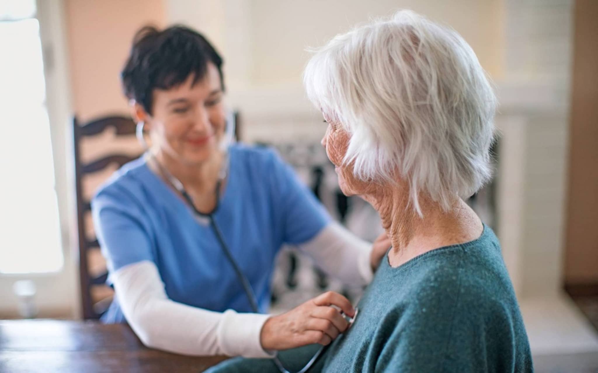 Vorsorge Hypertonie: Ältere Dame wird von einer Ärztin mit dem Stethoskop abgehört.